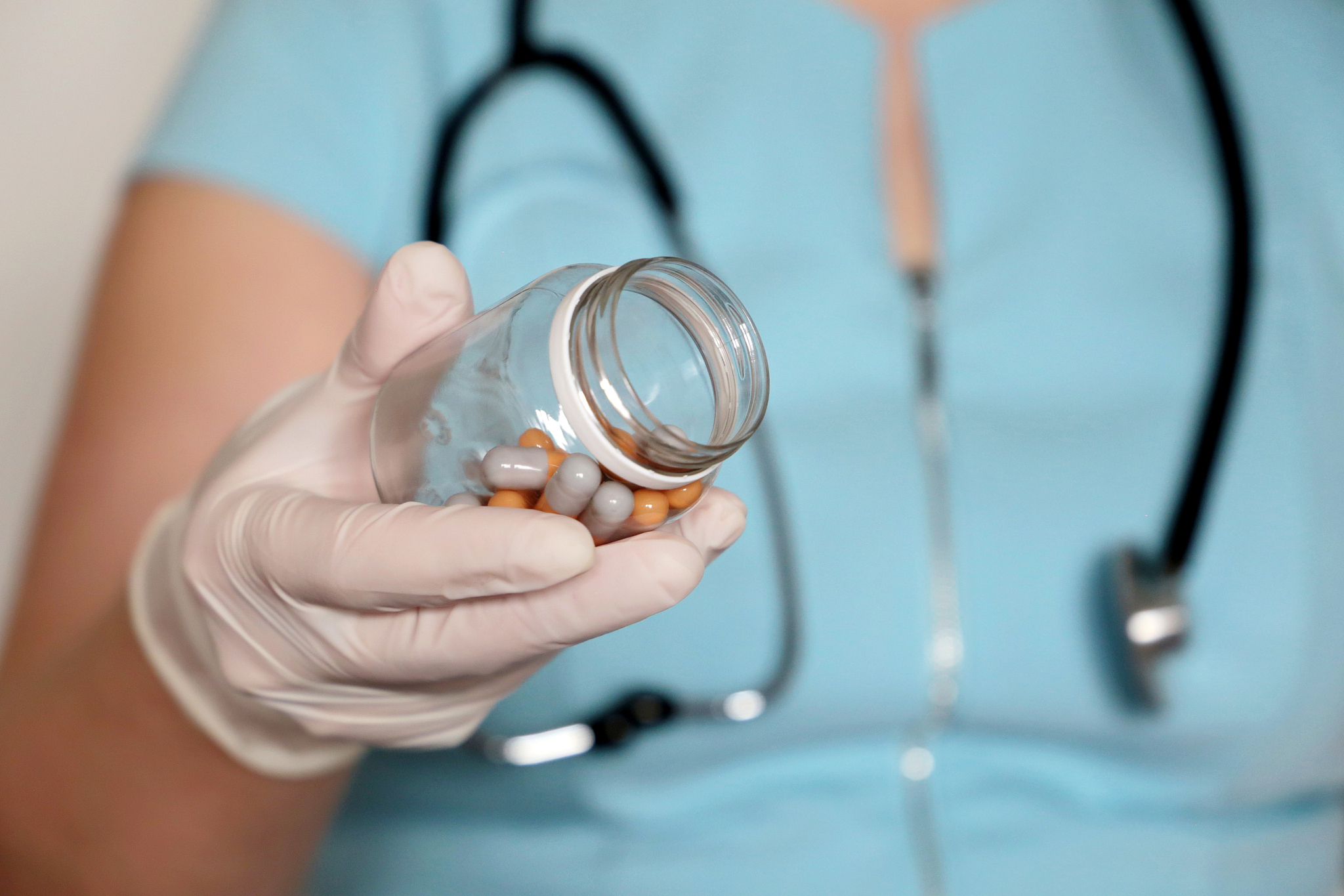 doctor with pills, woman in latex gloves giving bottle of capsul