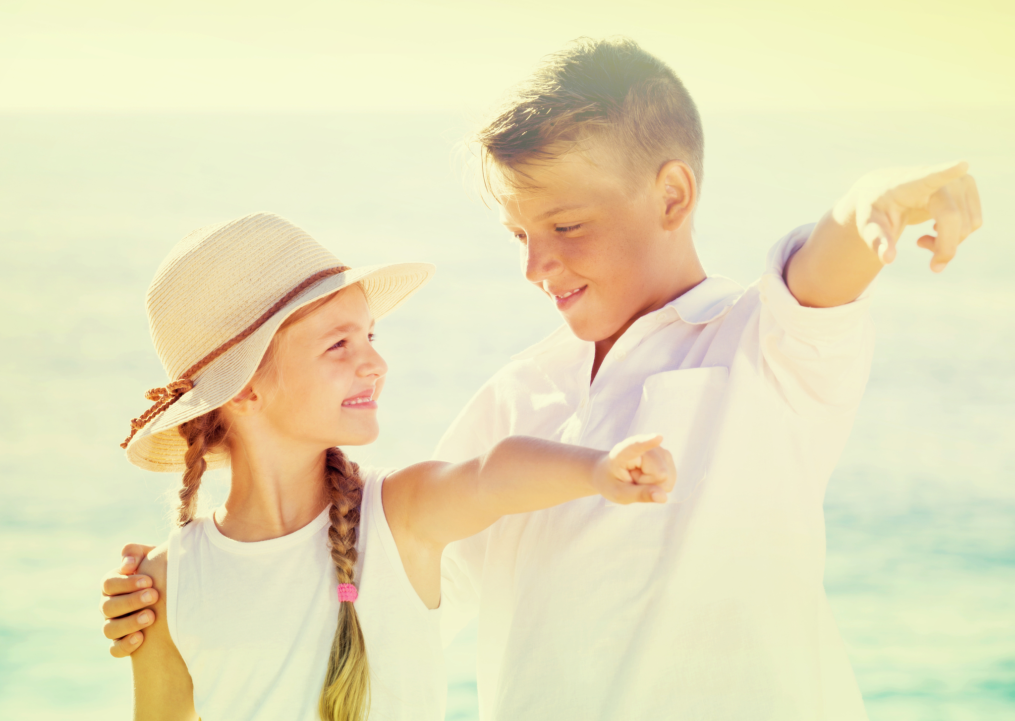 children pointing with finger on sandy beach