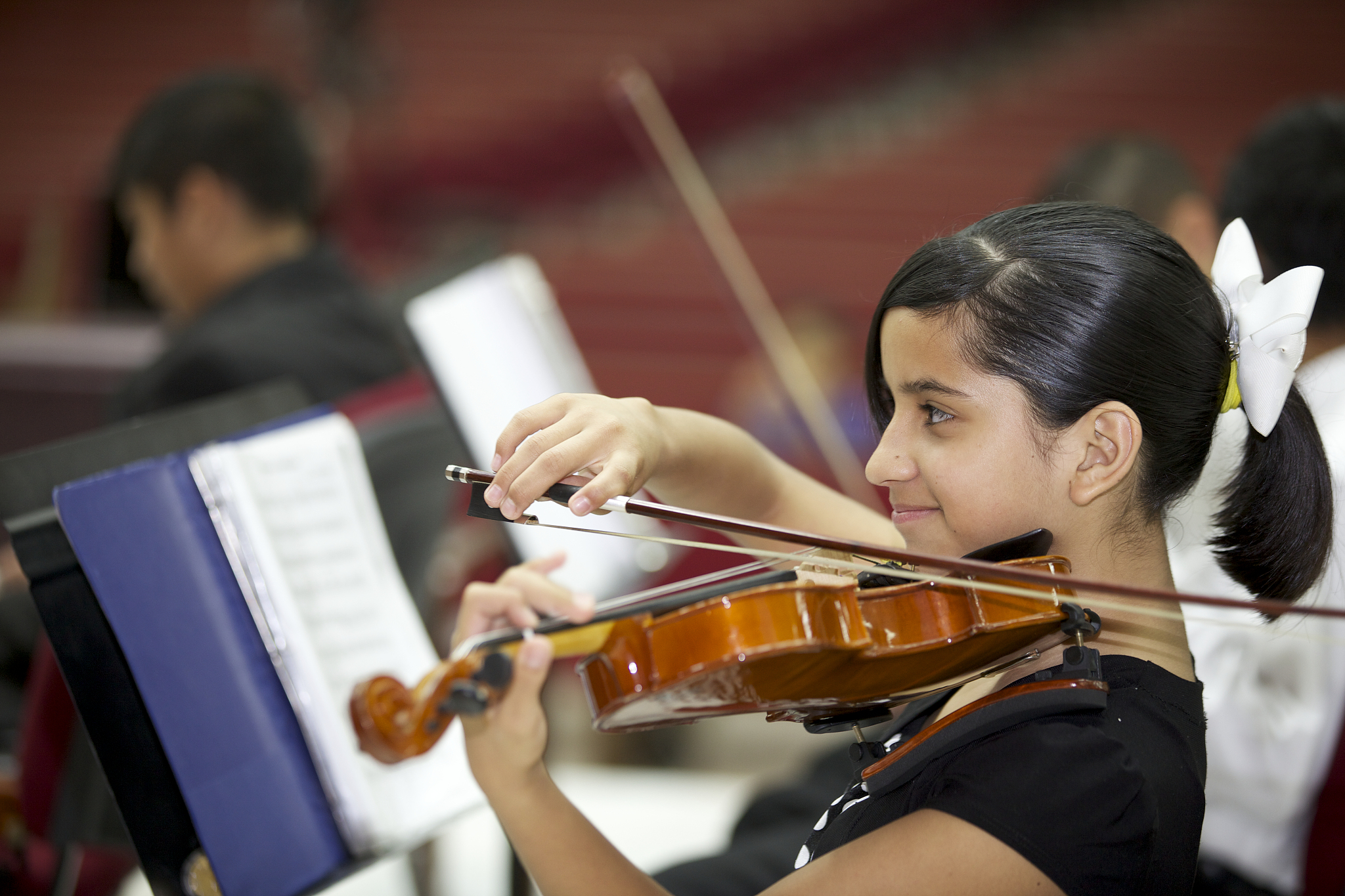 little girl playing with the orchestra.
