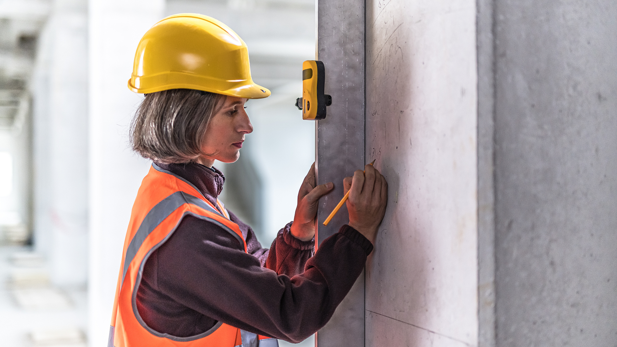 construction worker doing measurements on a construction site