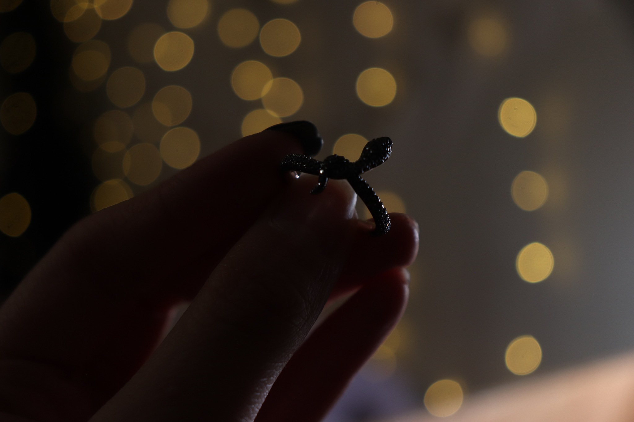 close-up of hand holding ring against lens flare