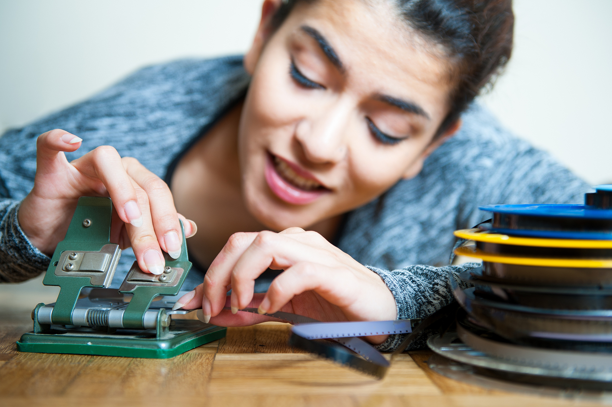 young woman editing 8 mm movie reel film