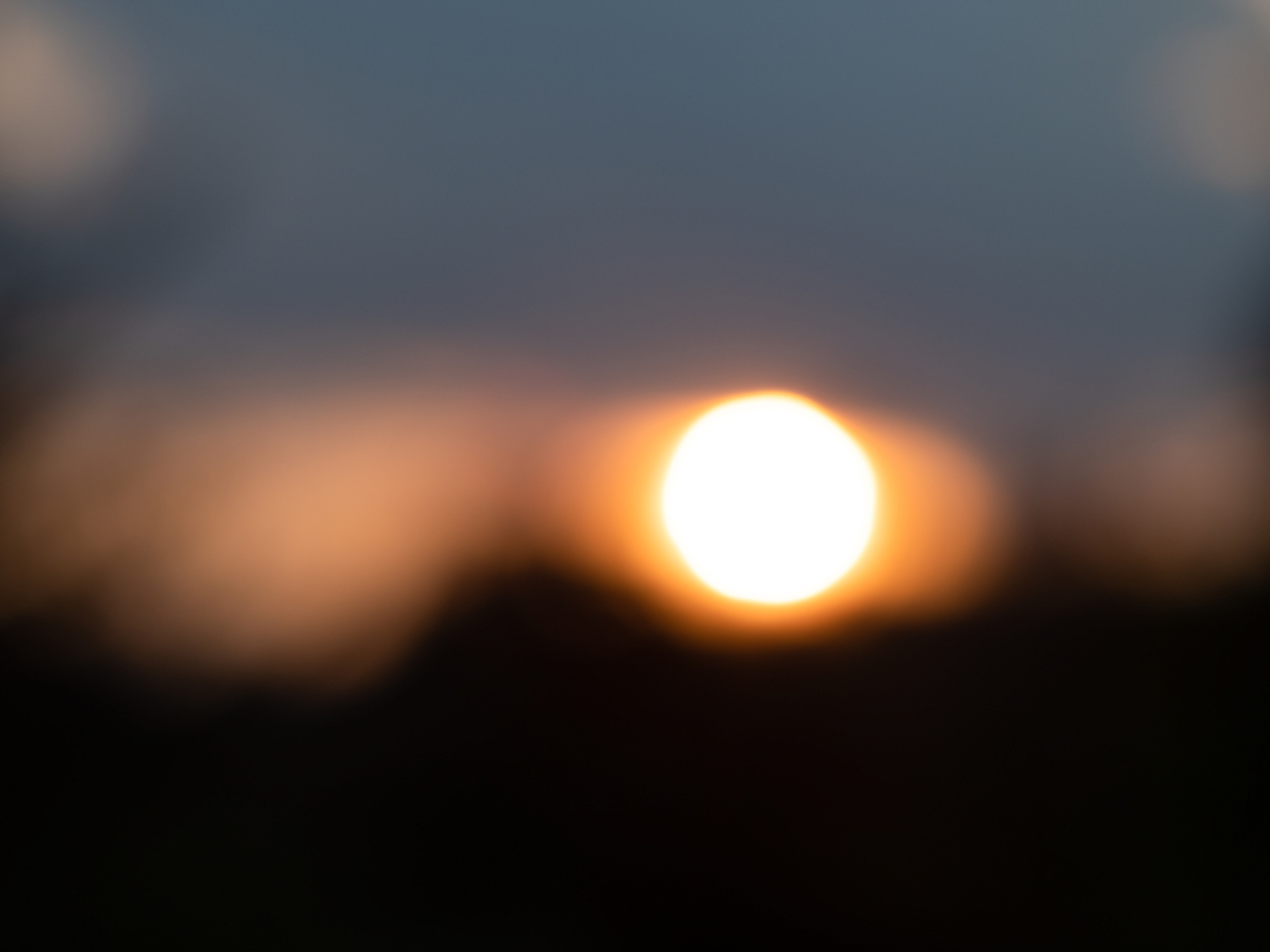 blurred background of view of beautiful sunset with meadow silho