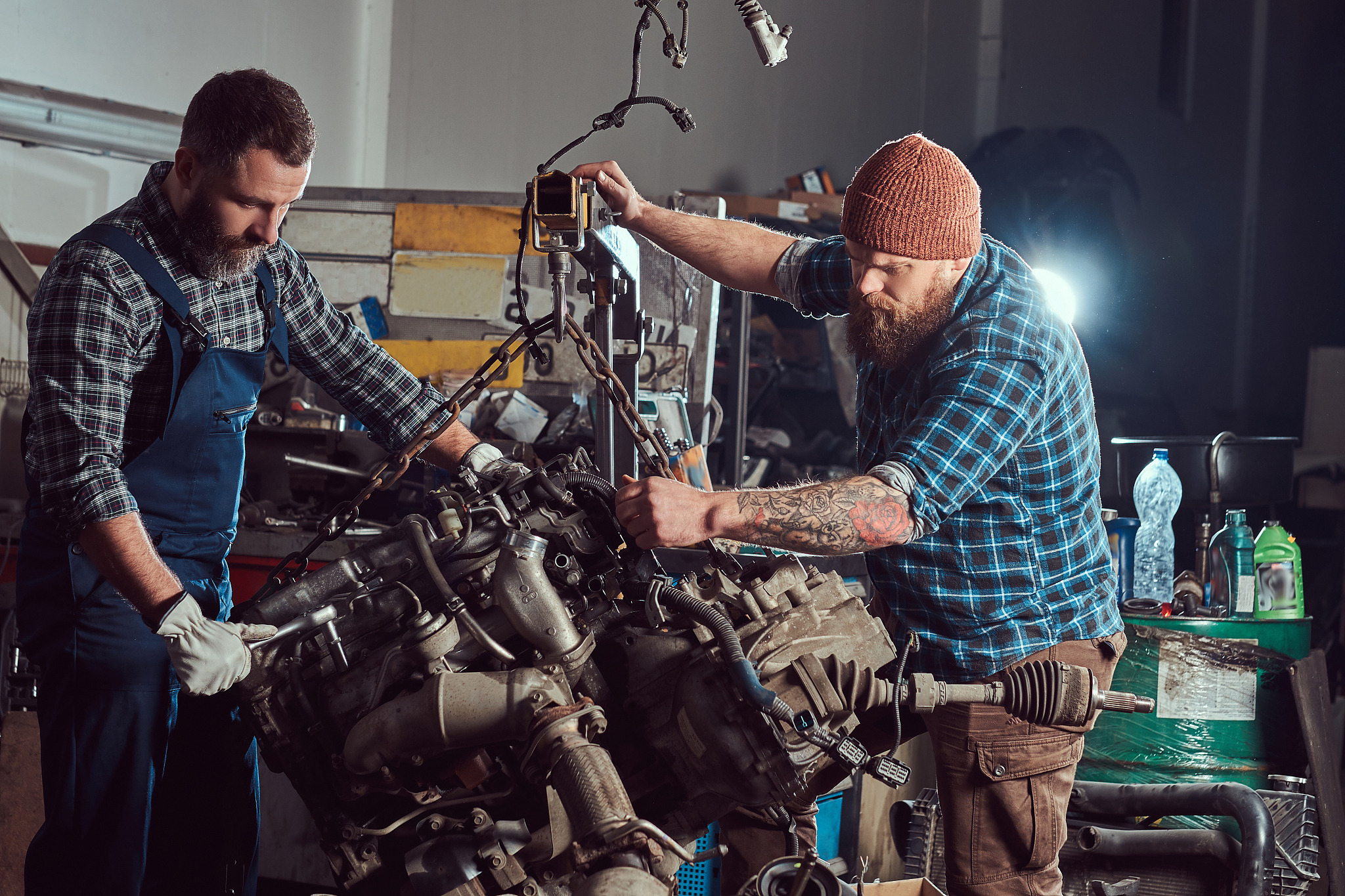 two bearded mechanics specialist repairs the car engine which is