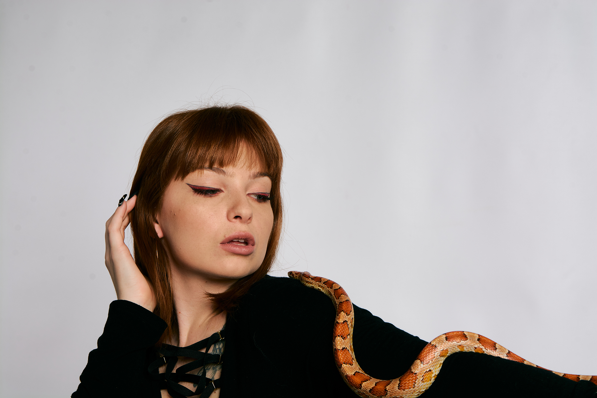beautiful woman in black bodywear and snake. ginger model girl w