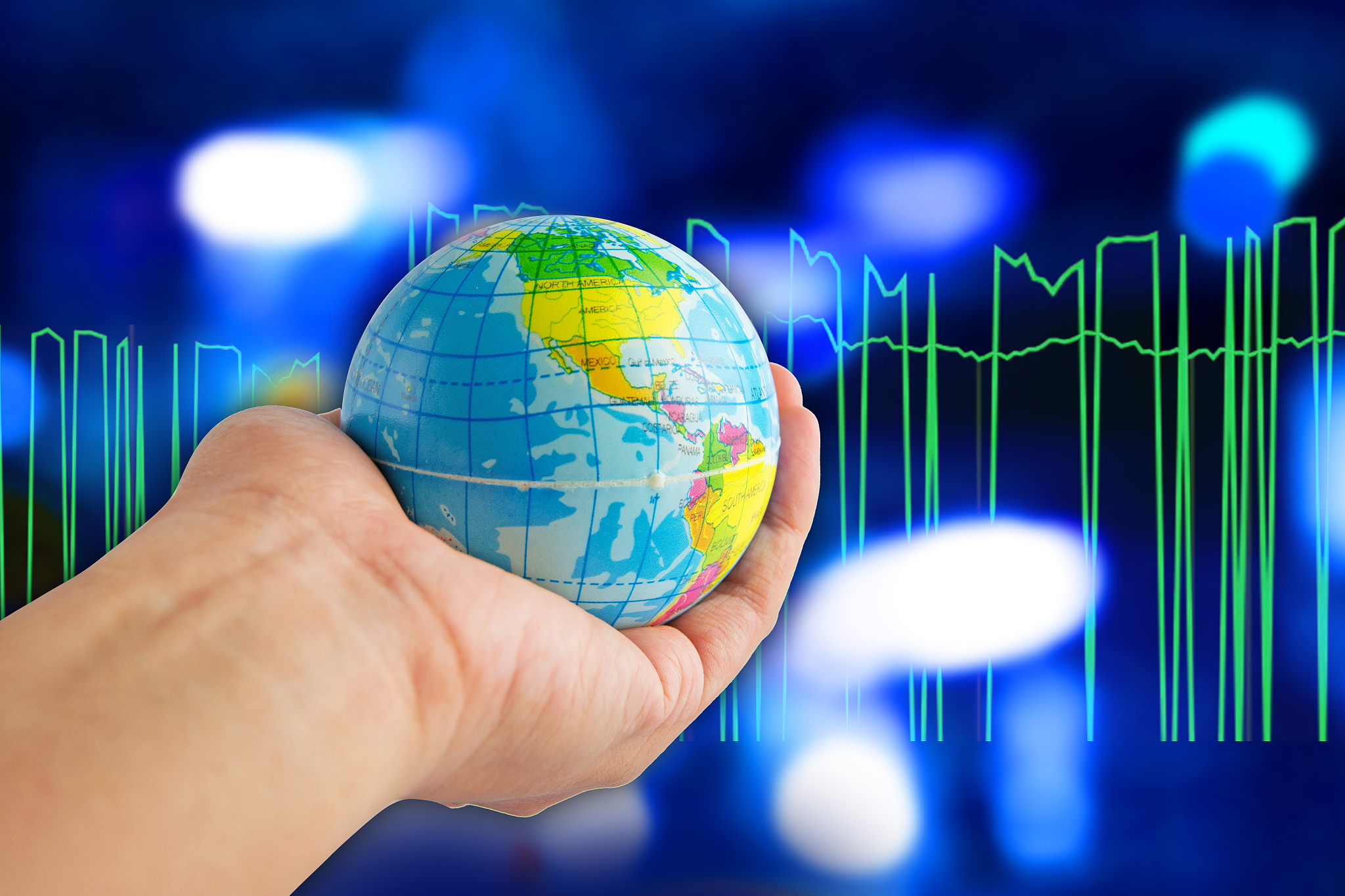 world in hand with blue color bokeh background.