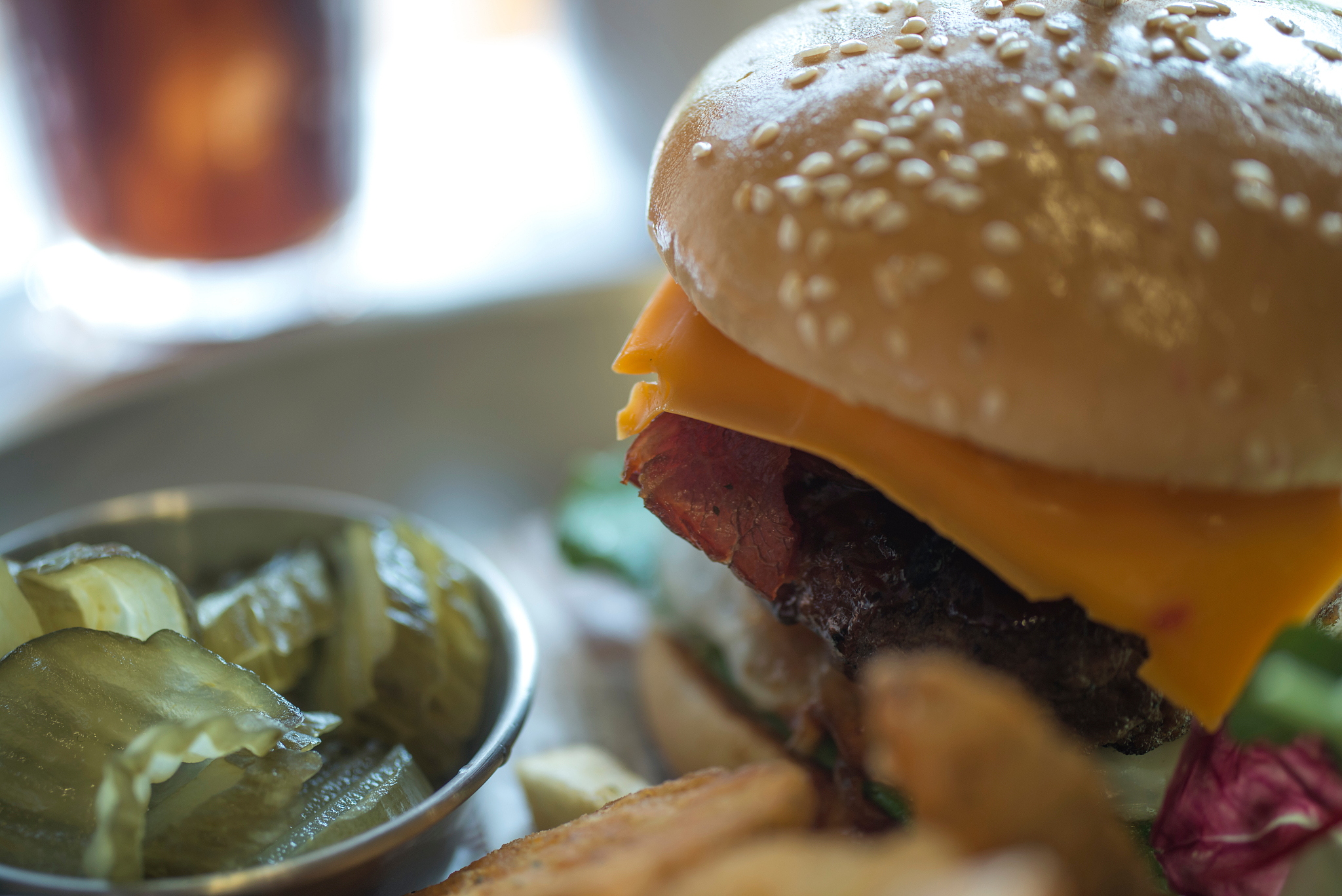 close-up of burger with pickle on table
