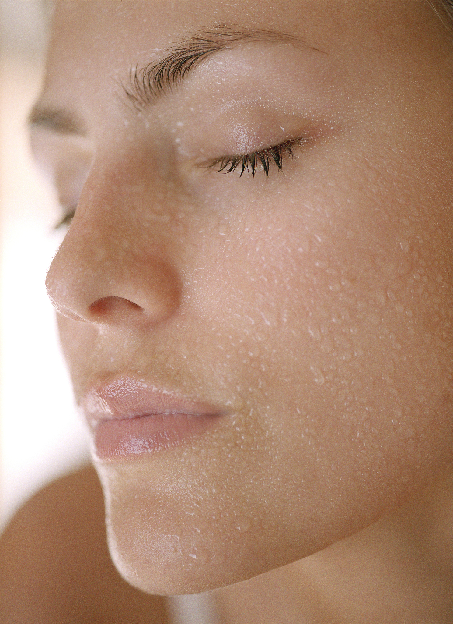 young woman with wet face, eyes closed, close up