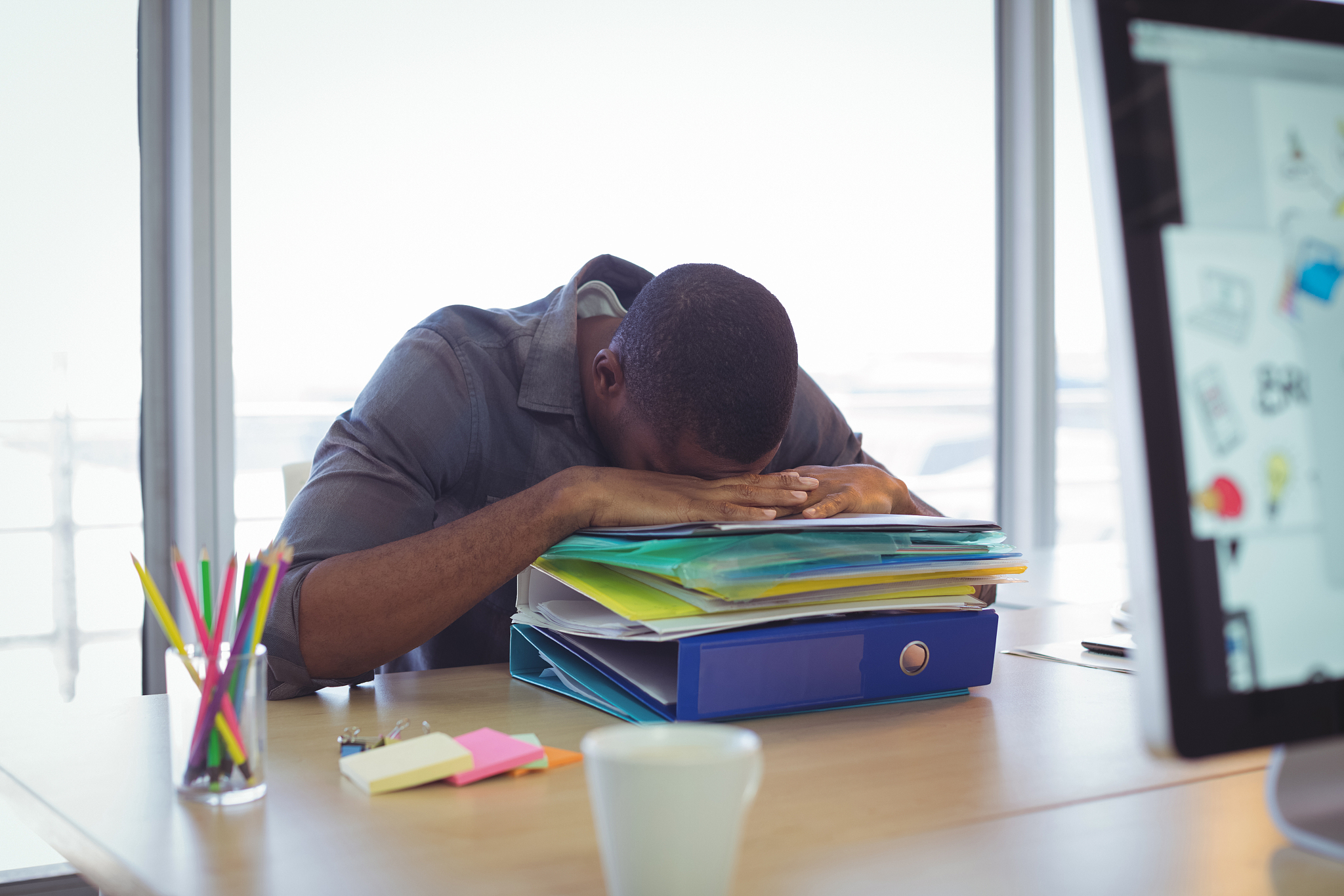 businessman sleeping on files at desk