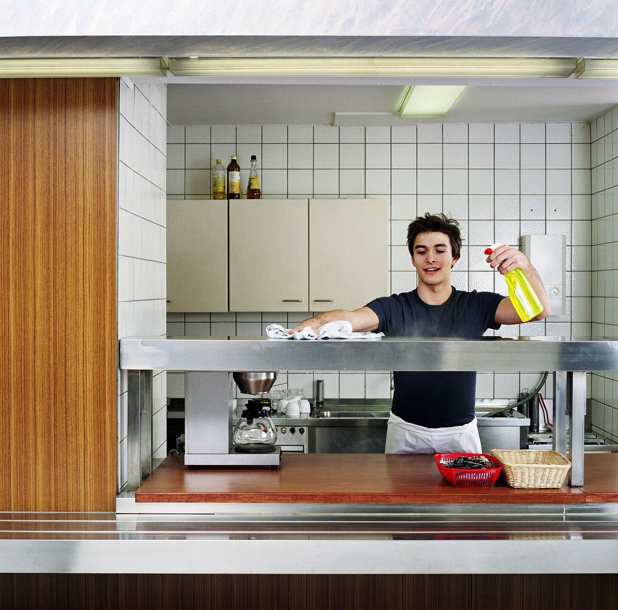 young man cleaning canteen kitchen