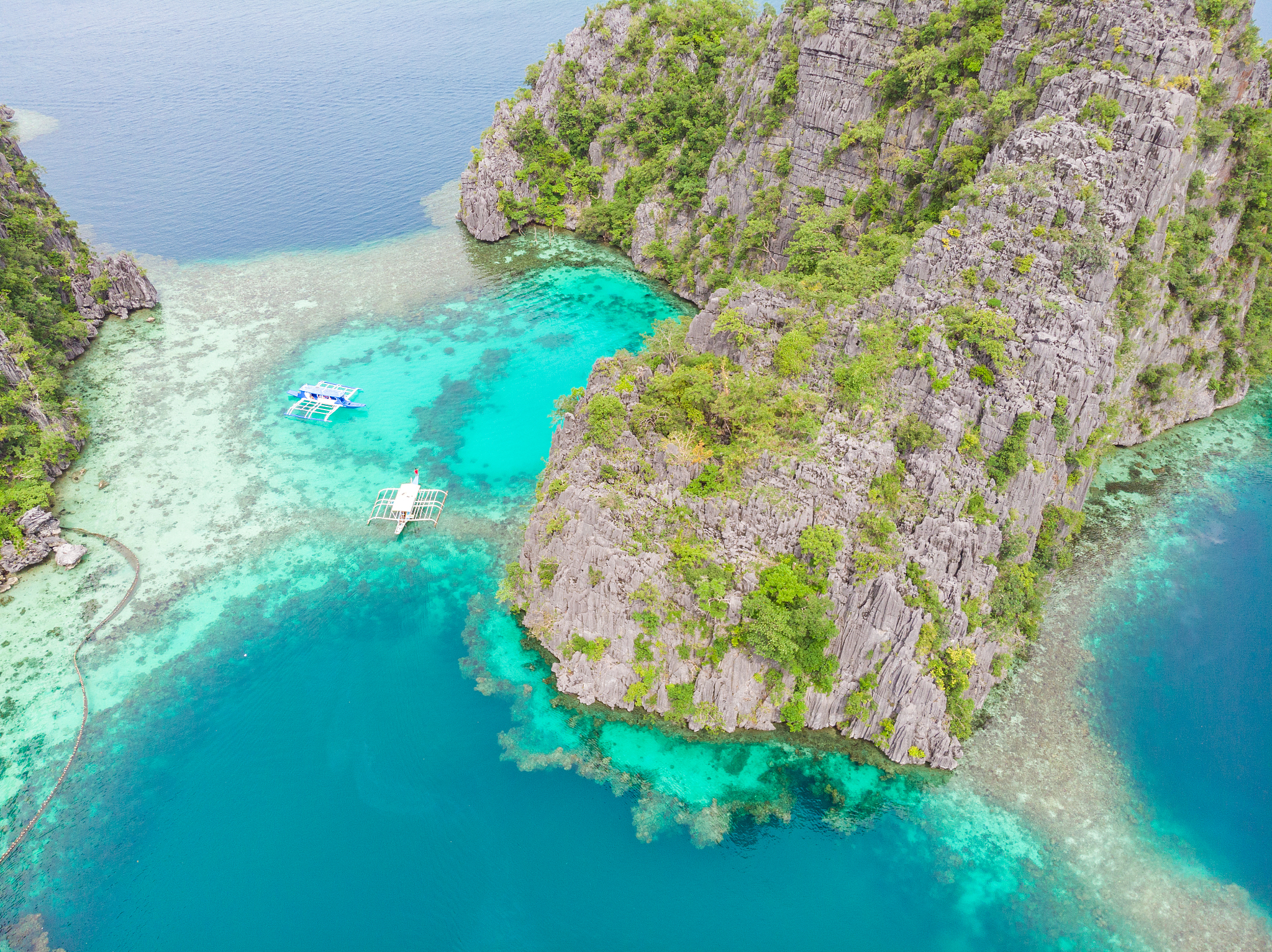 blue crystal water in paradise bay with boats on the wooden pier