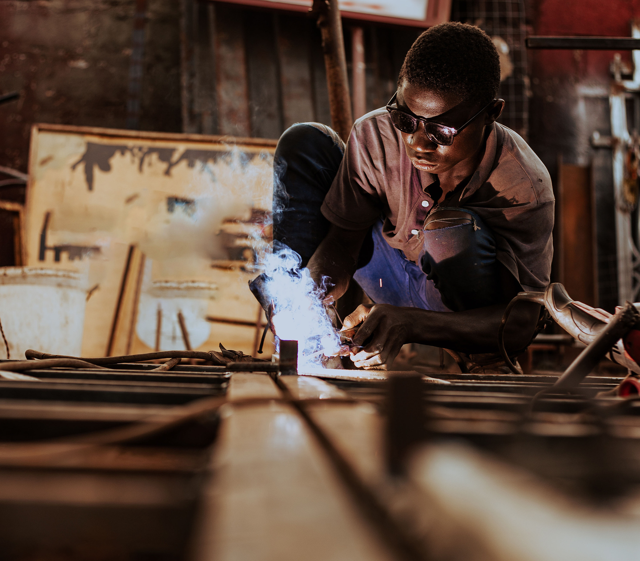 black man welding outdoors, tema, ghana