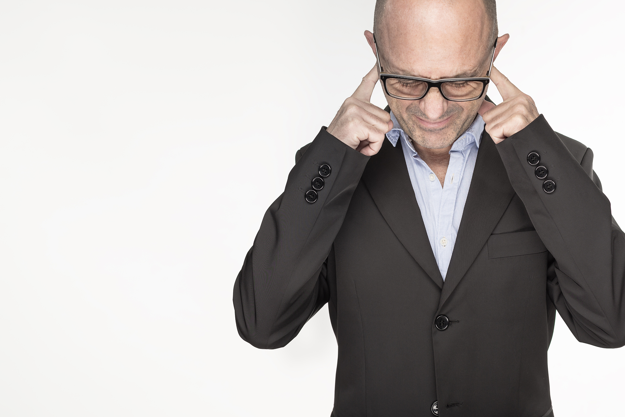 businessman with fingers in ears and eyes closed