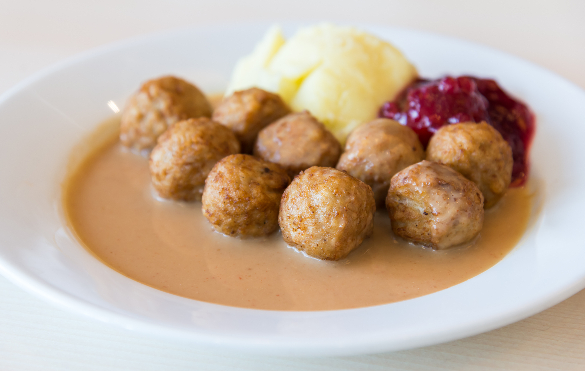 meat ball on gravy serve with mash potato and sauce.