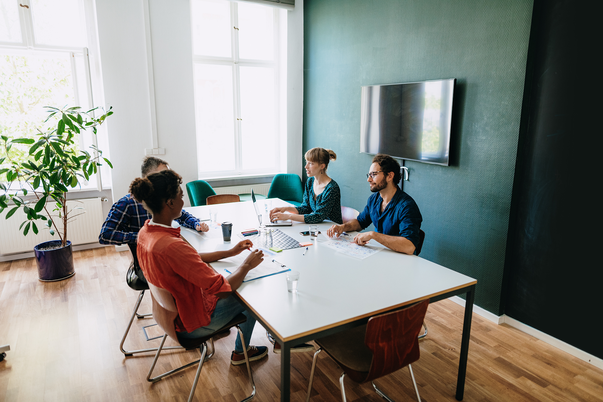 multi-ethnic millennials discussing new investment in online bus