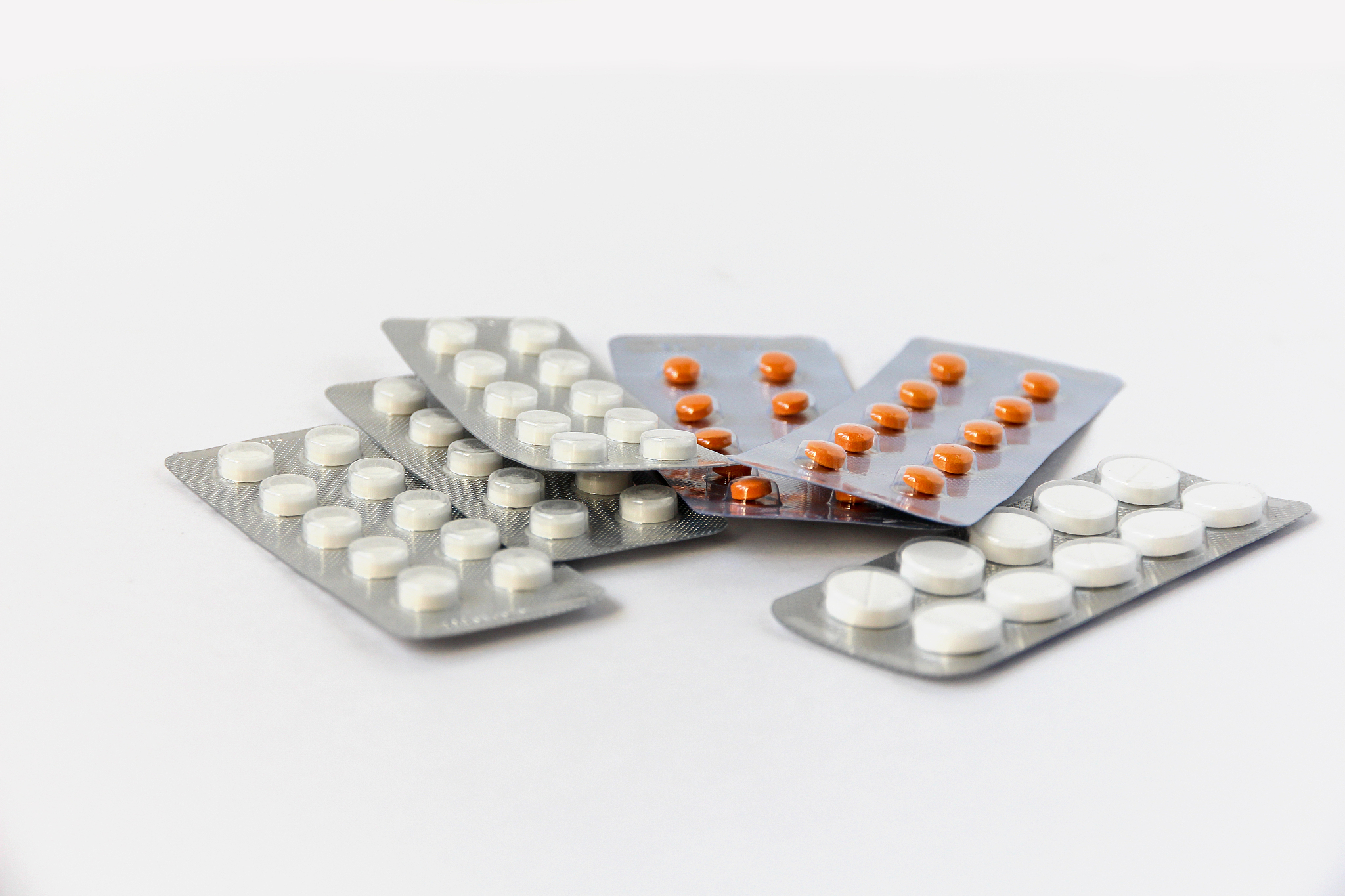 white and yellow medicinal tablets in blisters on a light backgr