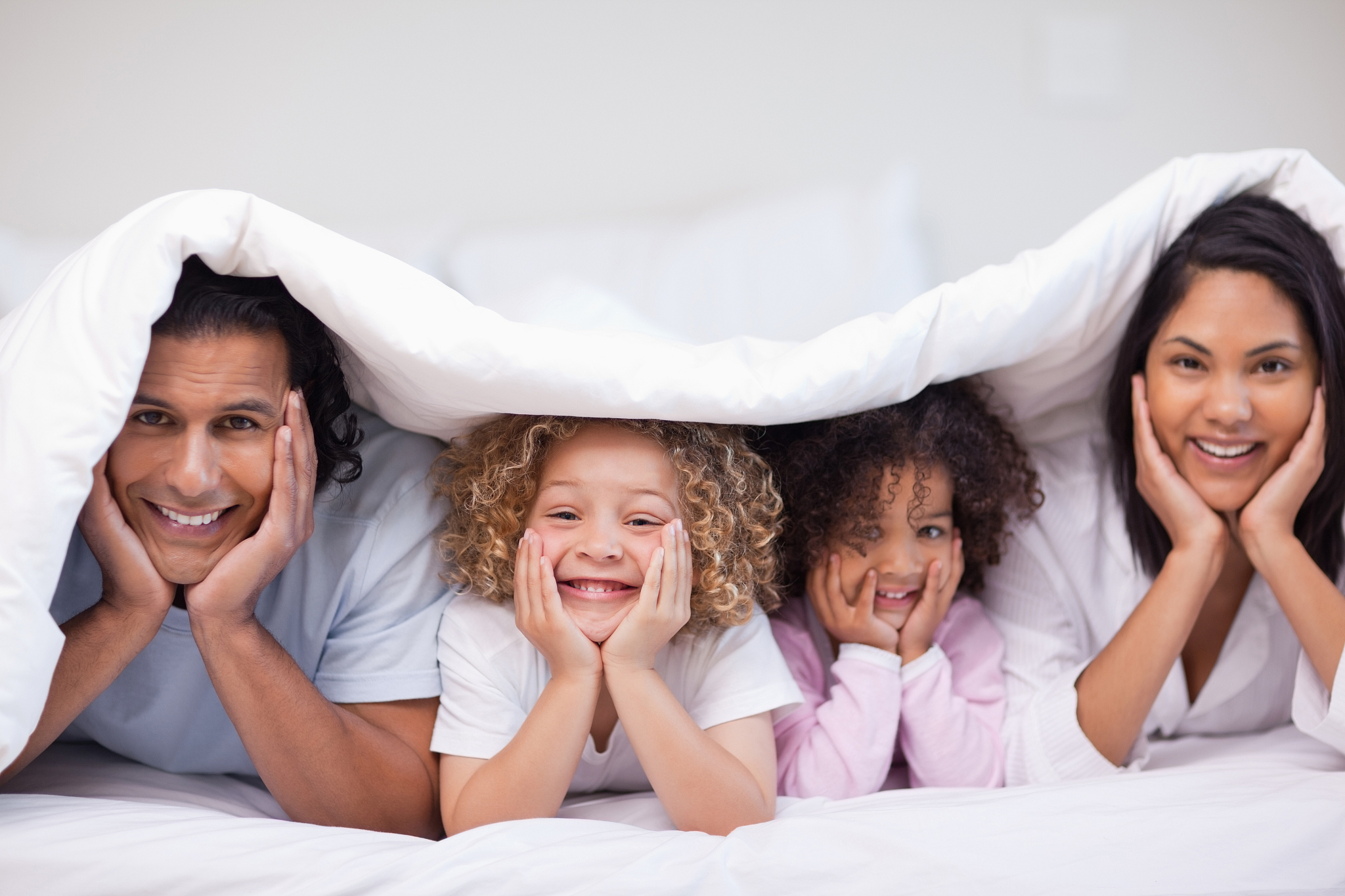 young family hiding under the blanket