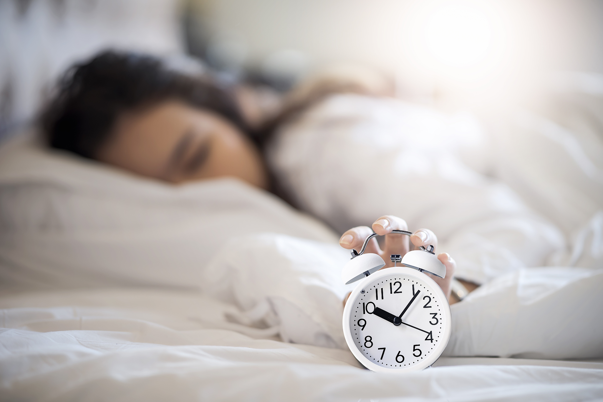 woman get up late in the morning and try to turning off the alar