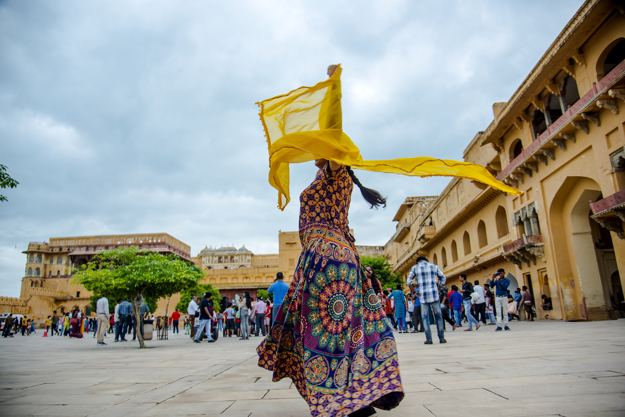 woman dancing inside the courtyard of amber fort, jaipur, rajast