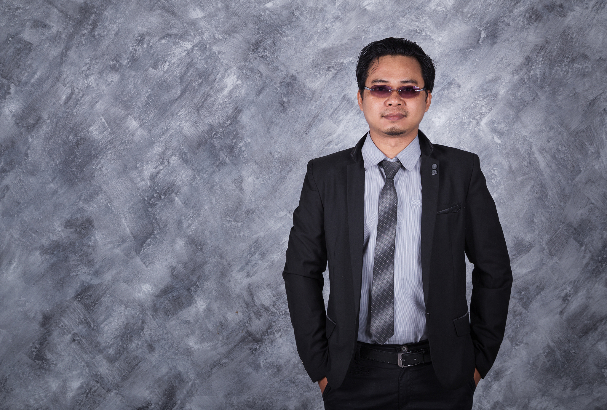 businessman standing with hands in pockets