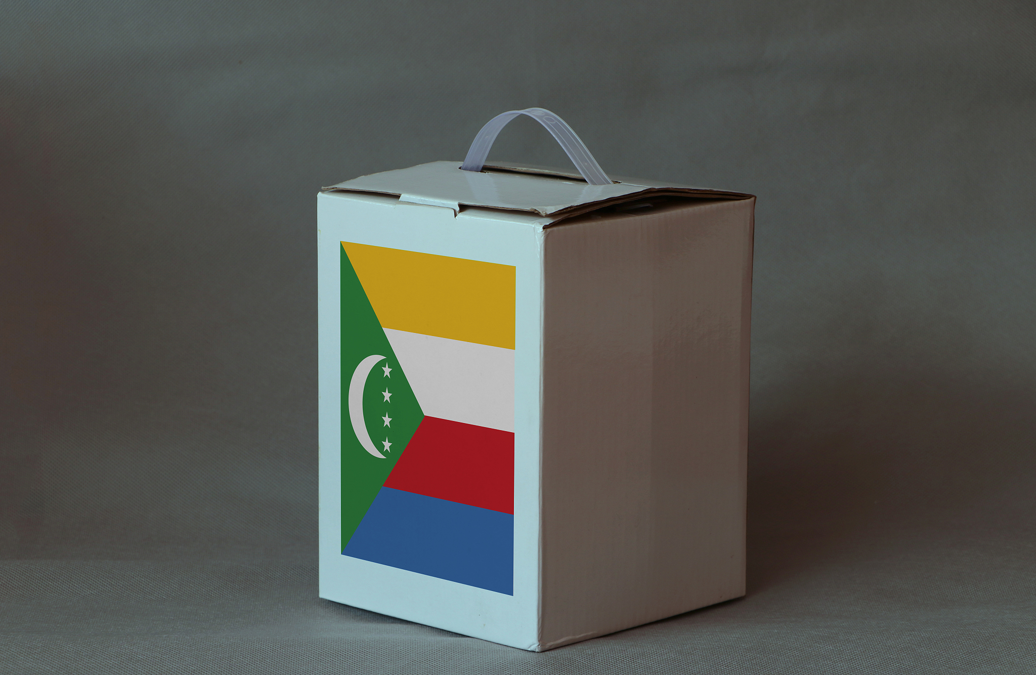 comoros flag on white box, paper packaging for put products. the