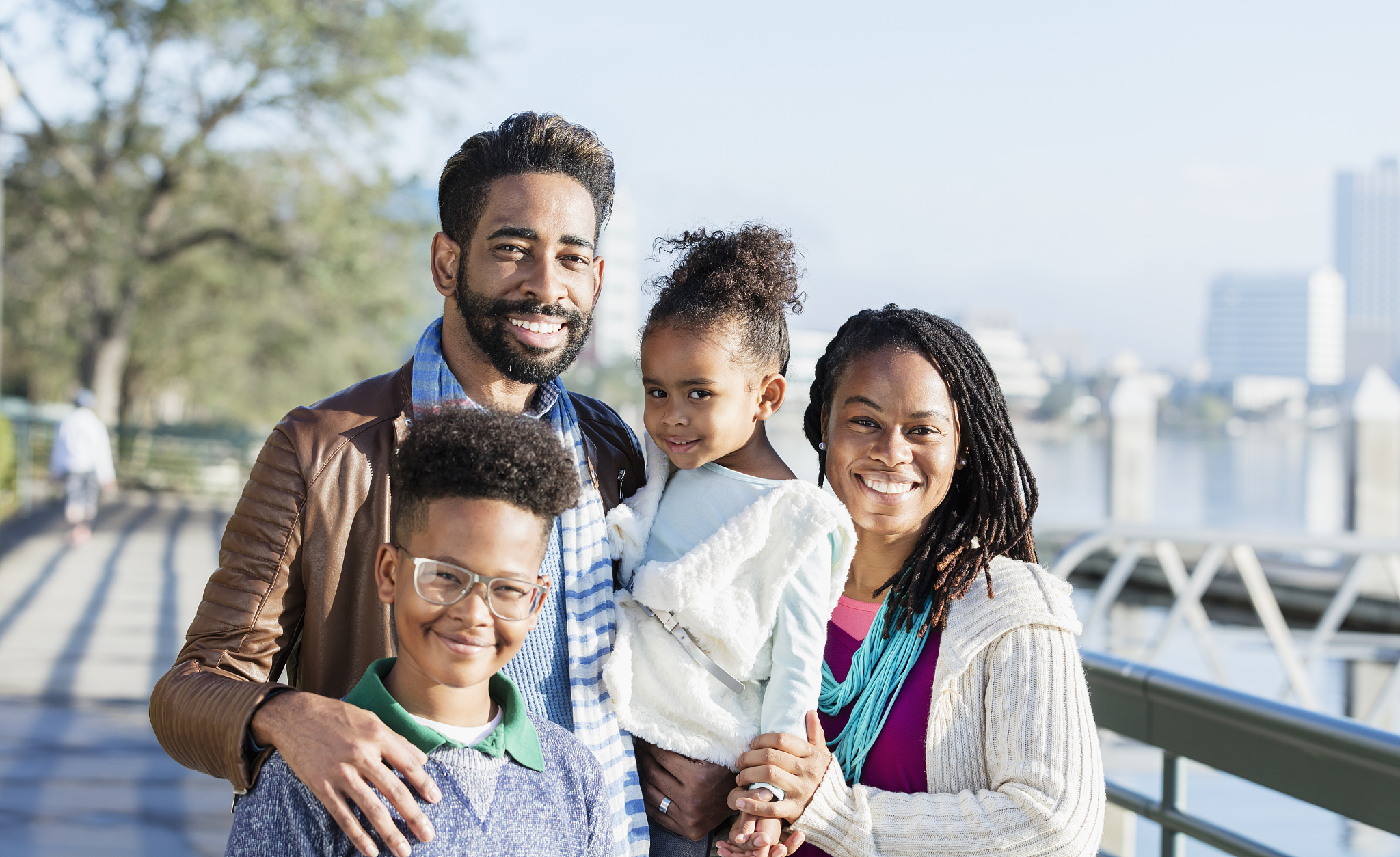 family with two children standing on city waterfront