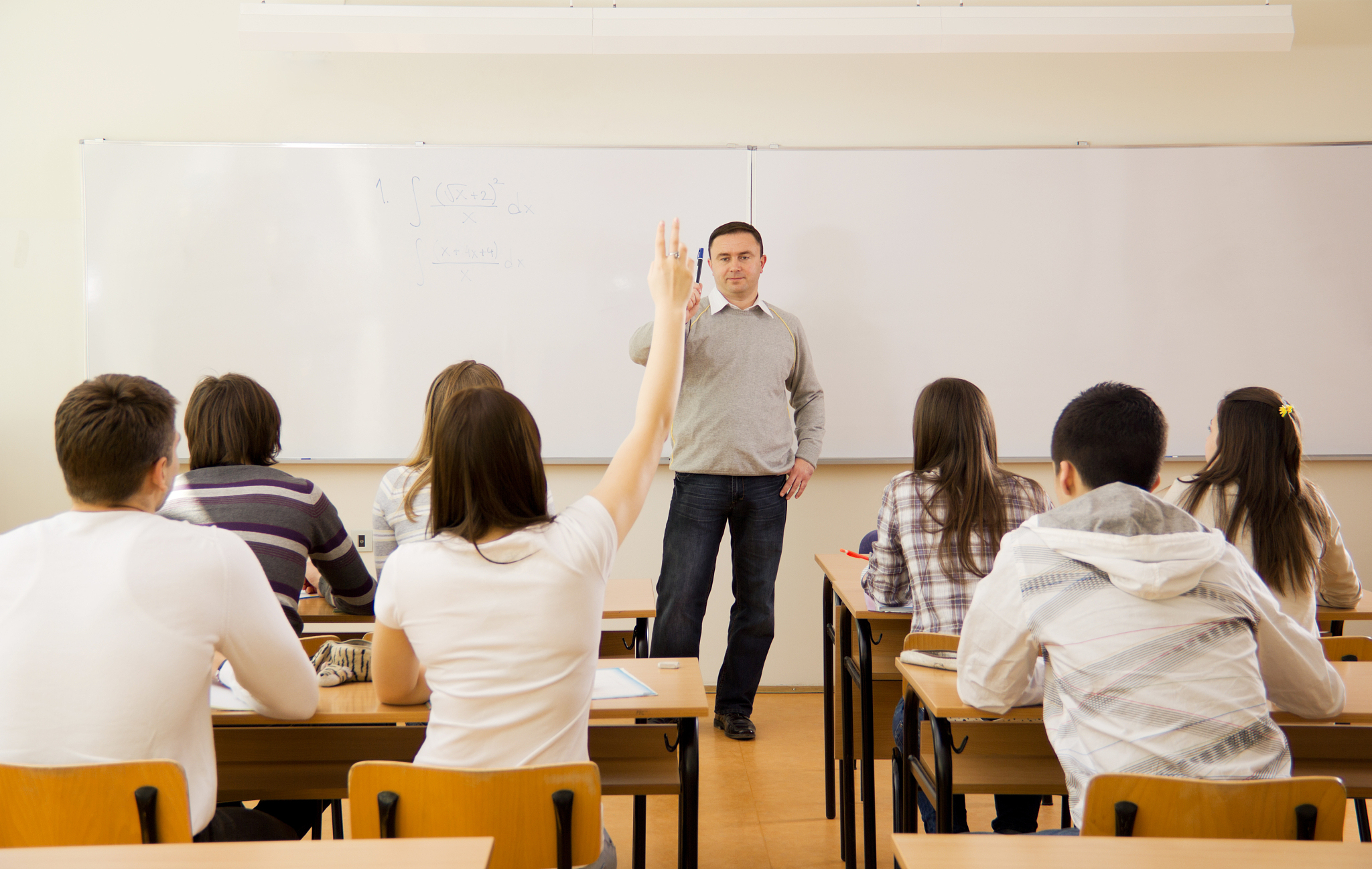high-school students in classroom, girl responding to teacher's