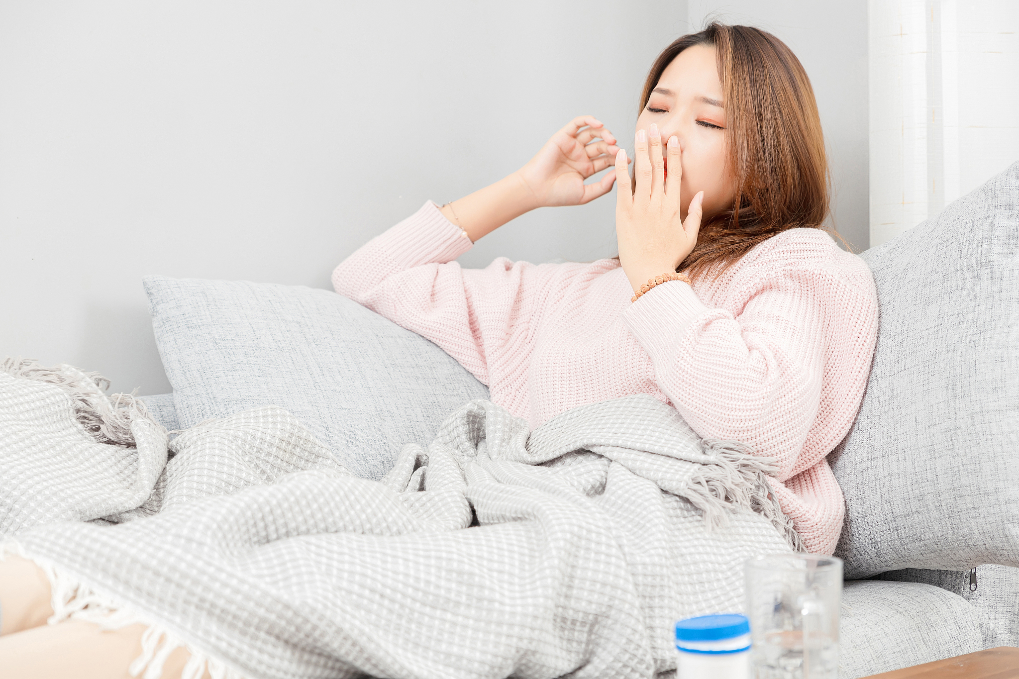 坐在沙发上感觉鼻塞的亚洲女孩