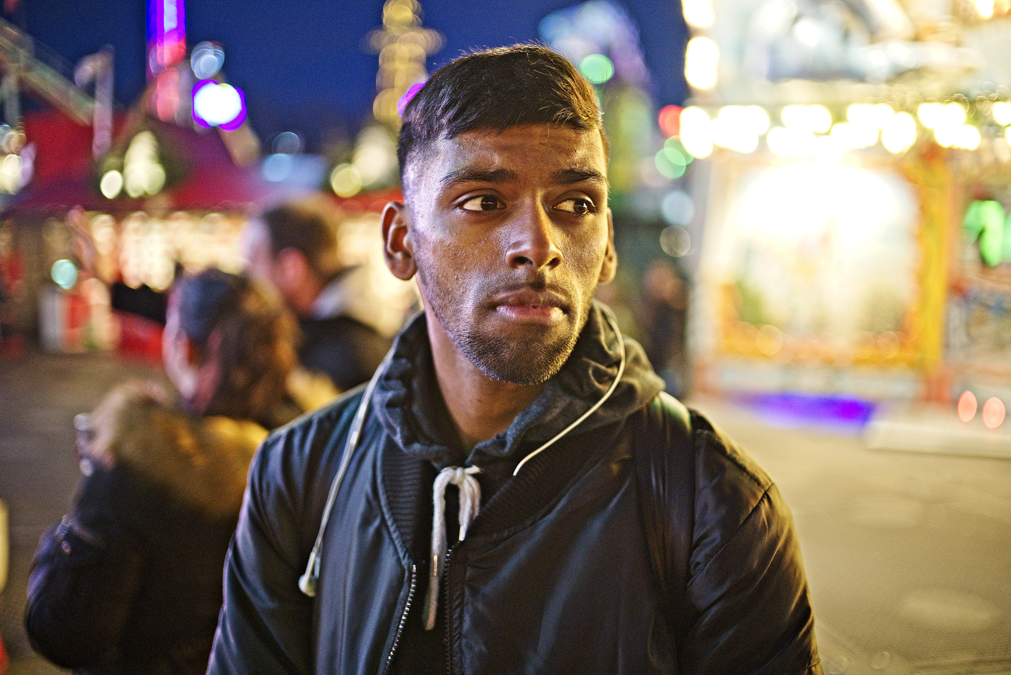 a young man waiting at the fun fair.