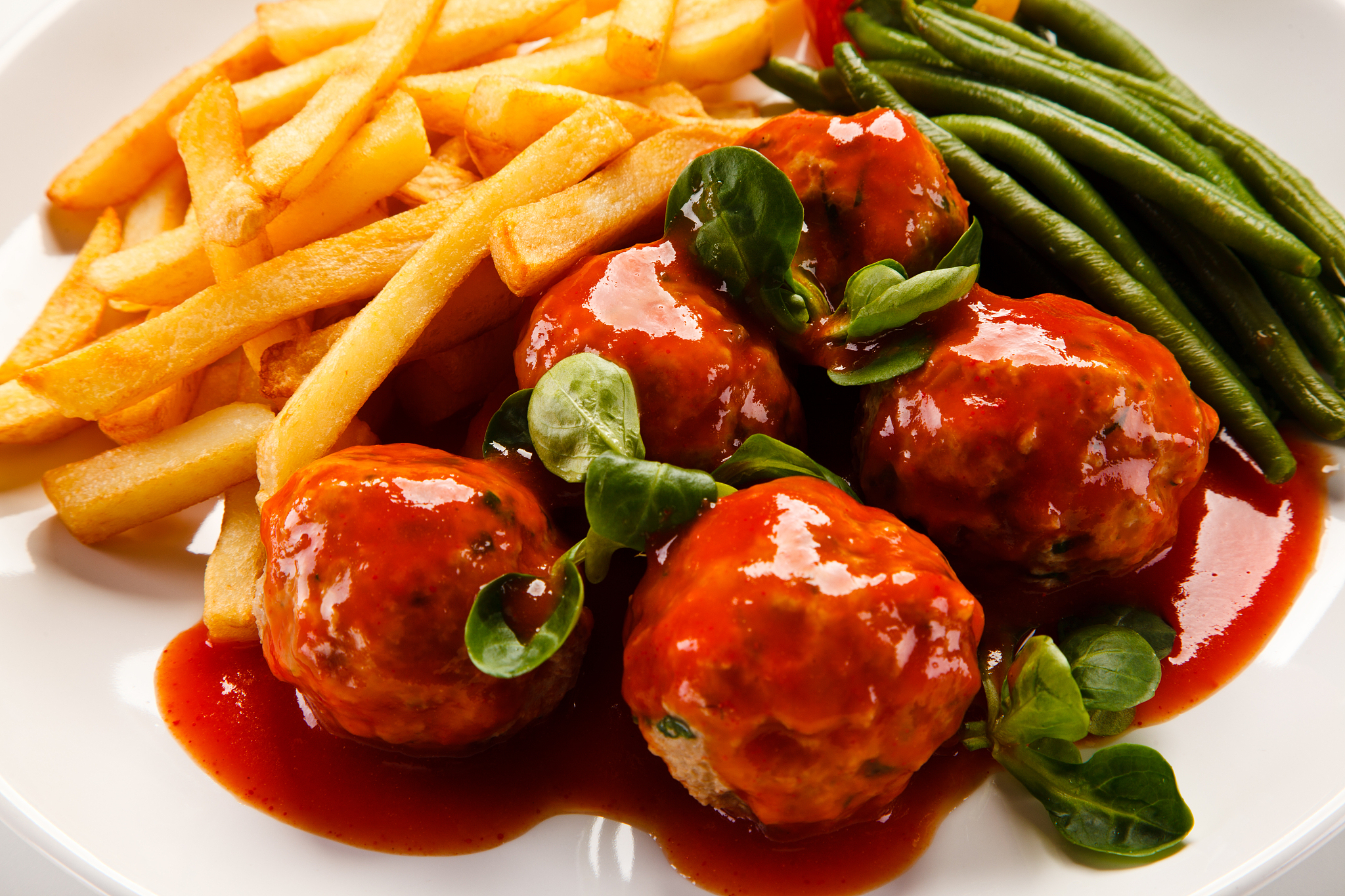 roast meatballs, baked potatoes and green beans on white backgro