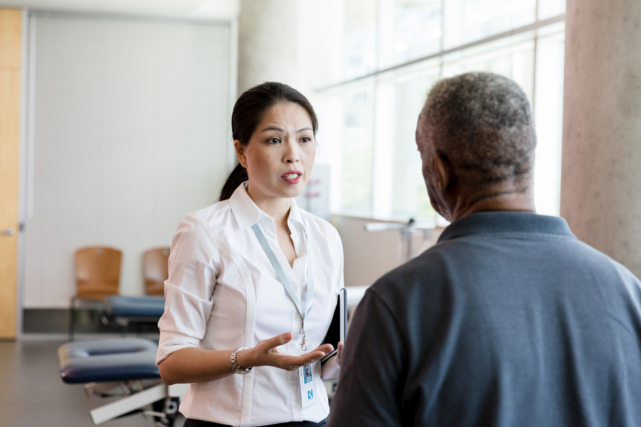 mid adult doctor explains physical therapy to stroke victim