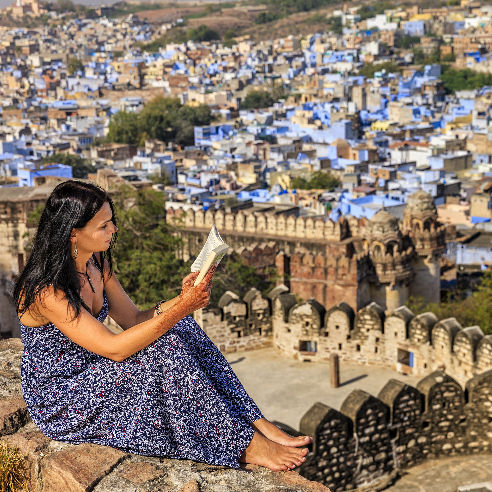 young female tourist reading book, jodhpur, india