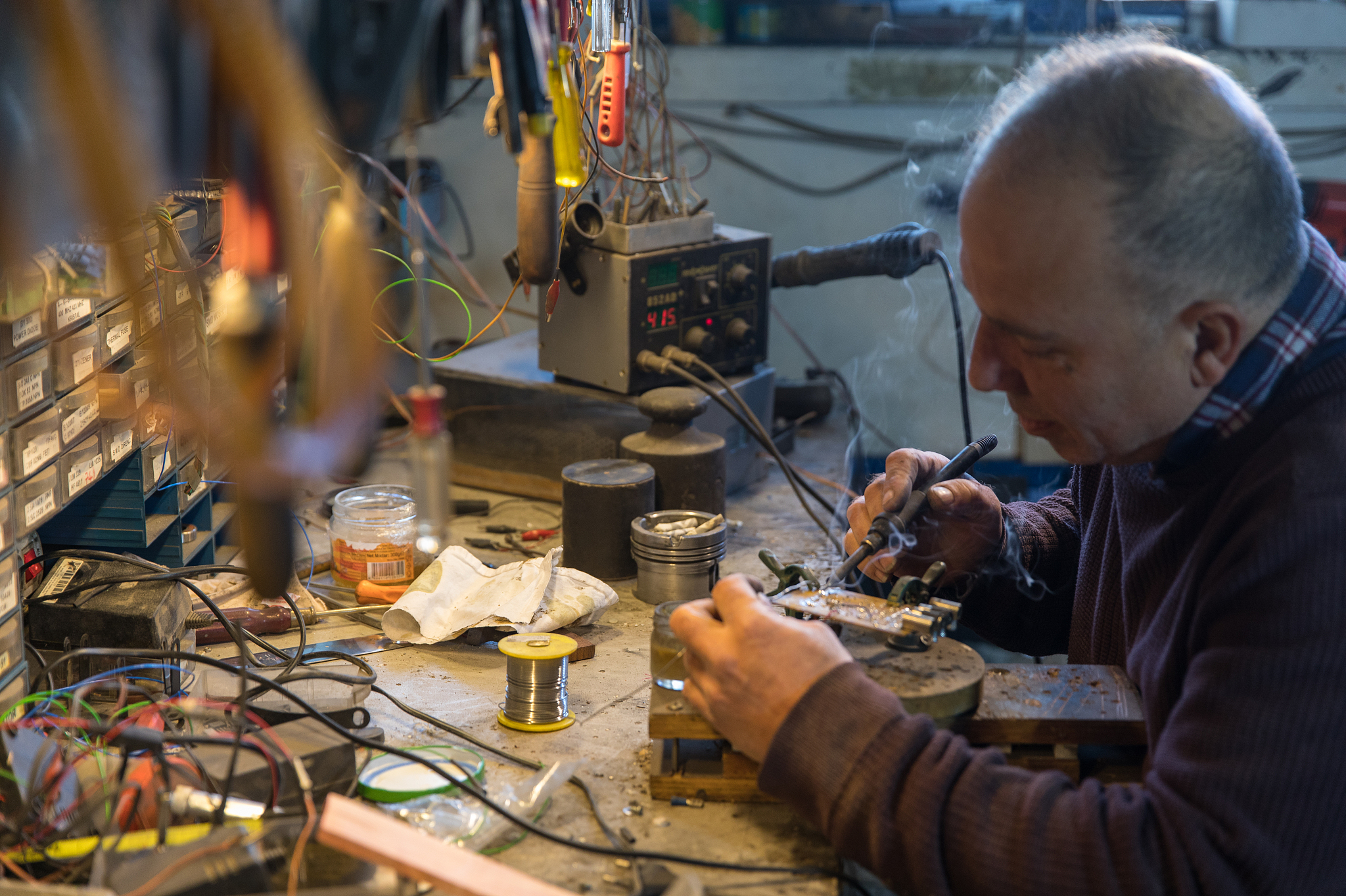inventor man solldering electronic circuit board - computer moth
