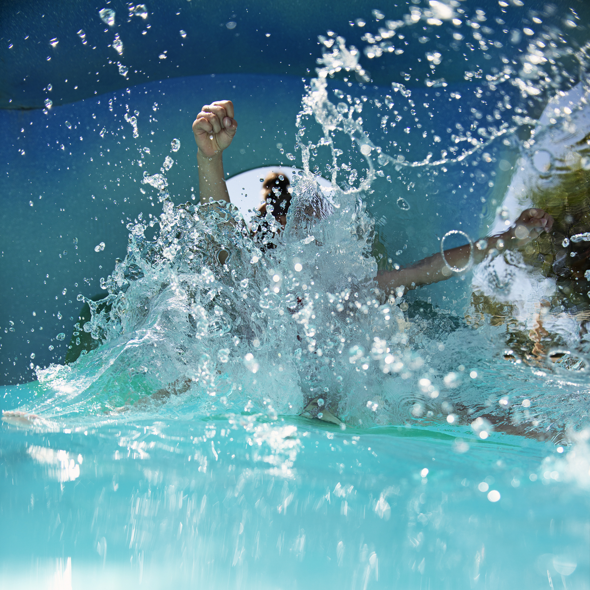 child sliding and splashing in water park