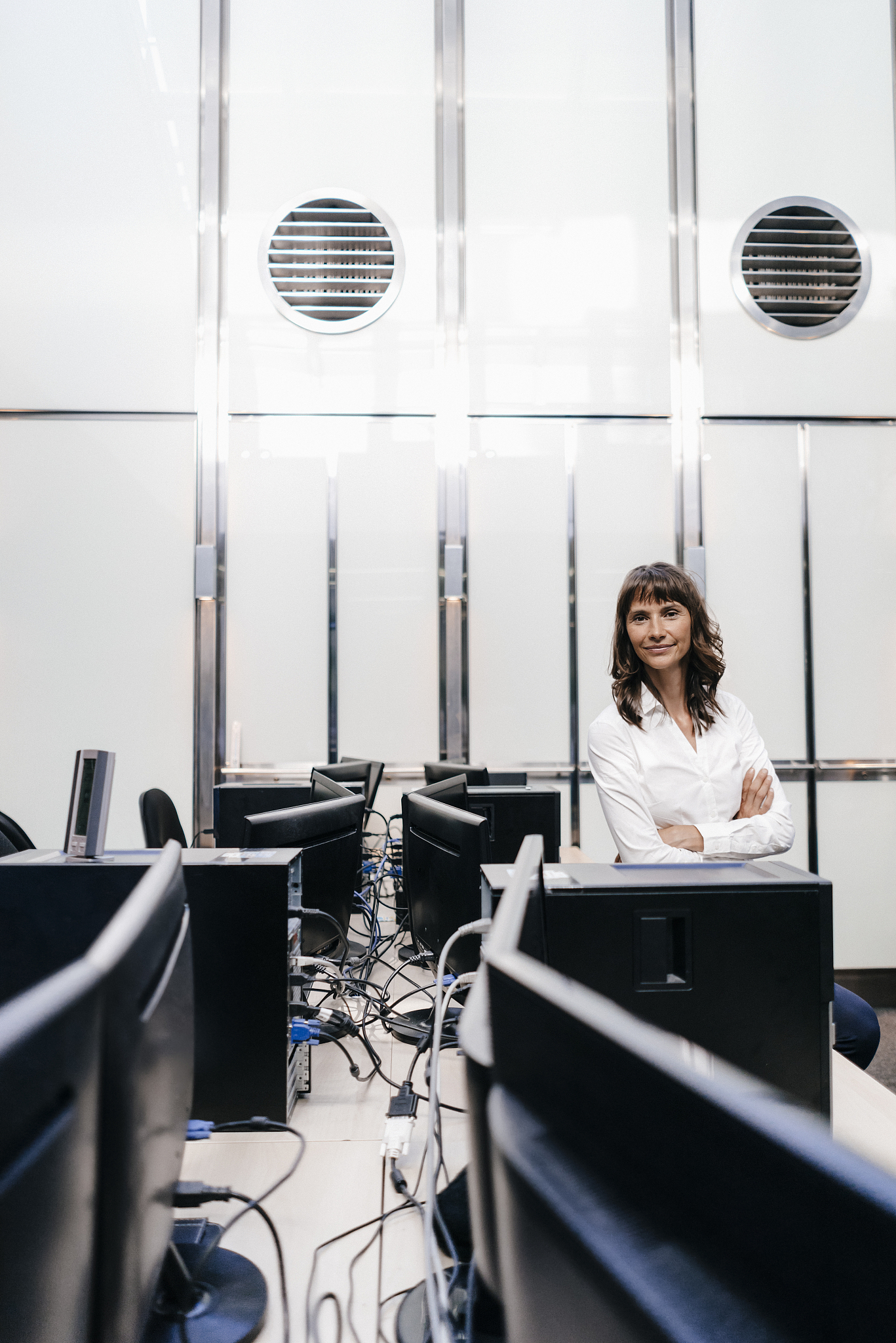 successful businesswoman standing in office, looking at camera
