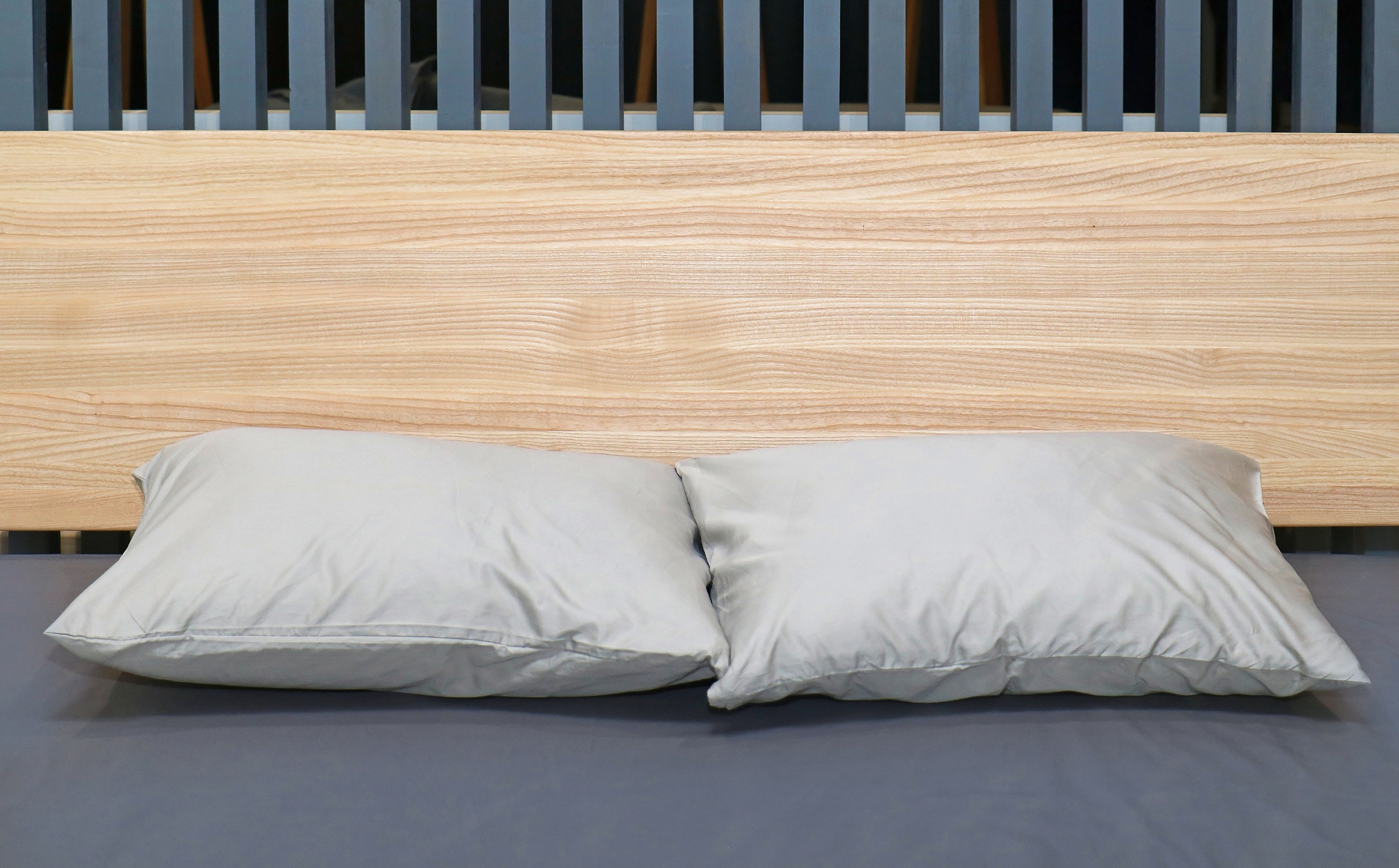 pillows on bed with wooden headboard
