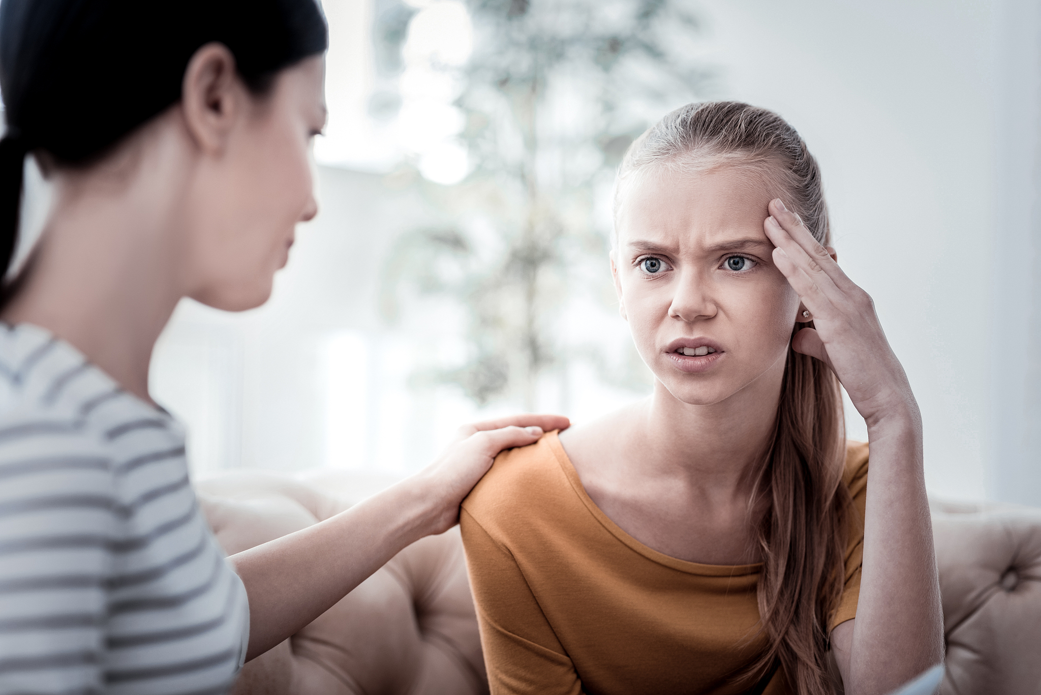close up of annoyed girl touching her head