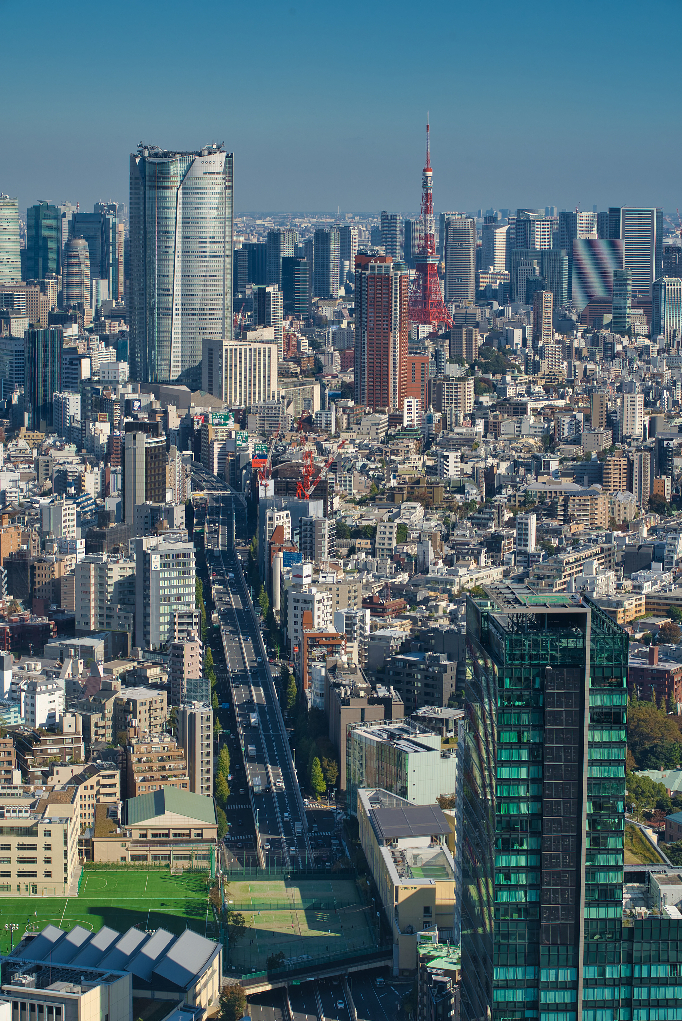 elevated view of tokyo tower and crowded skyscrapers in tokyo