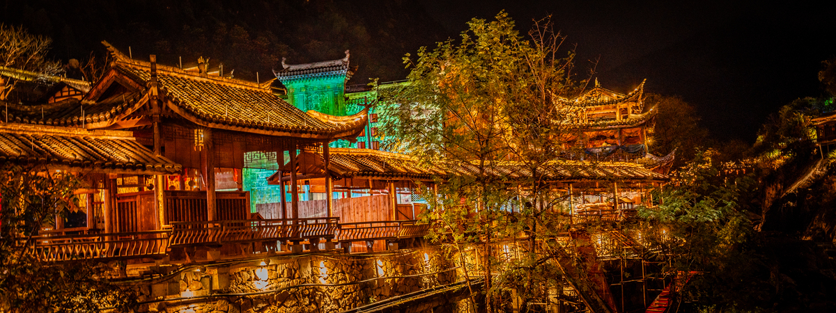 描写一段唯美的青茅山雨夜里古月山寨高脚吊楼万家灯火的景象