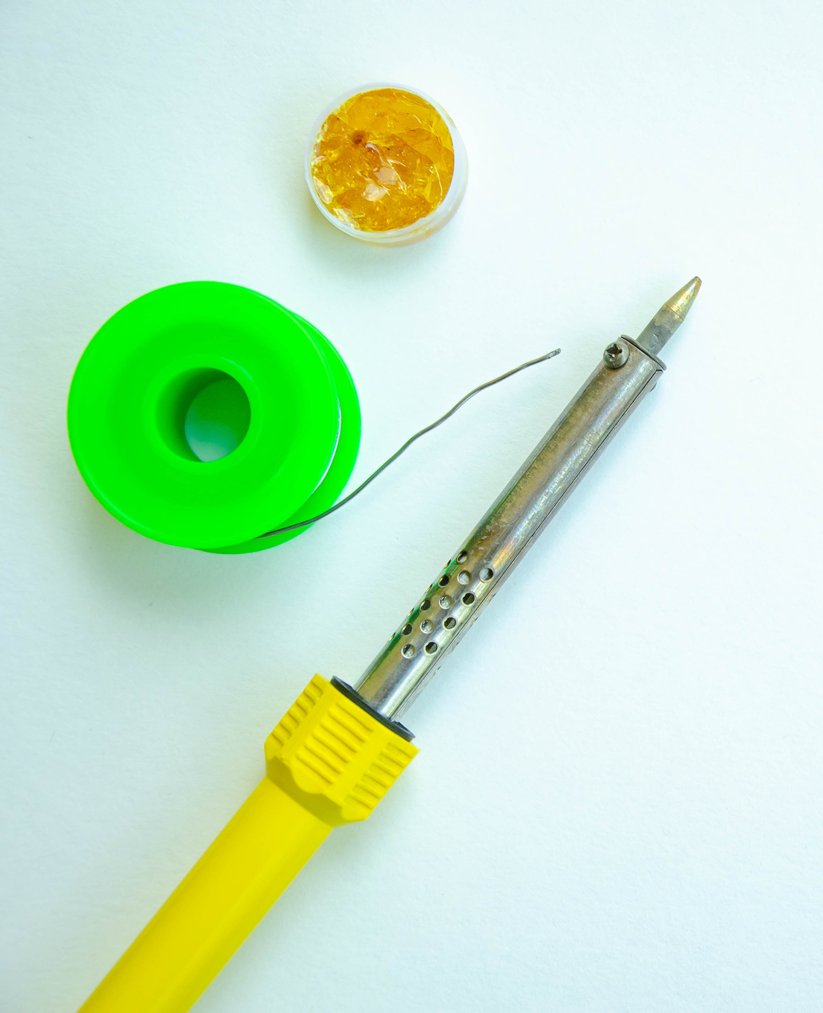 soldering iron, tin, rosin on a yellow background. macro. repair