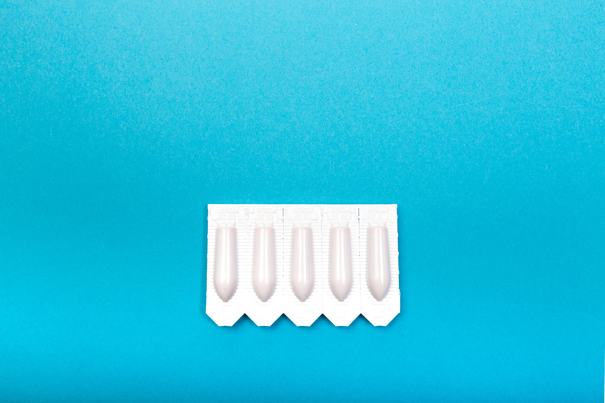 plastic packs of suppositories on blue  background - image