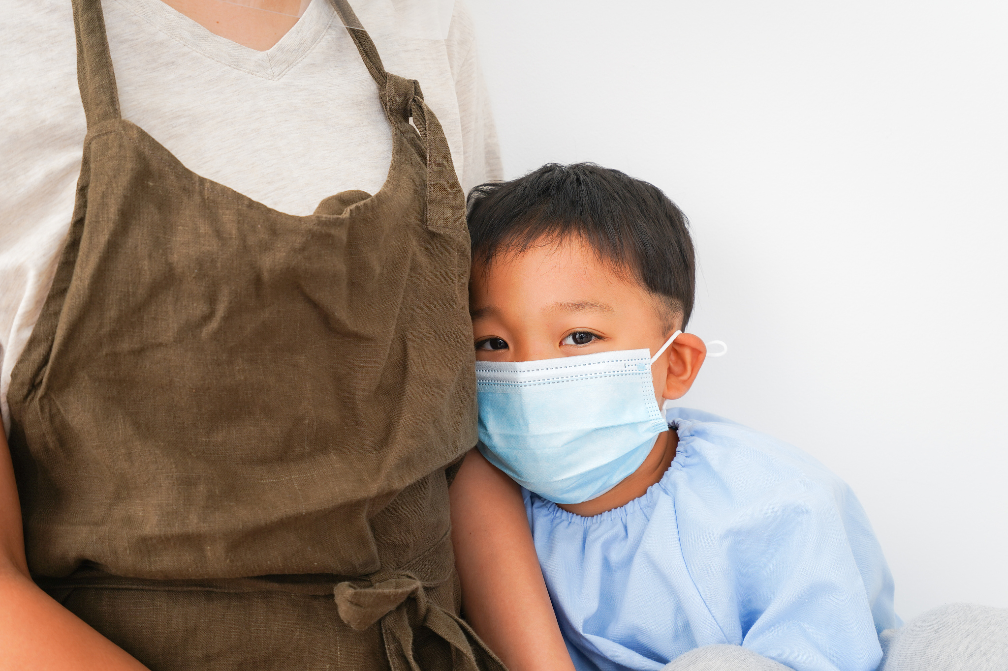 preschool teacher measuring child's body temperature