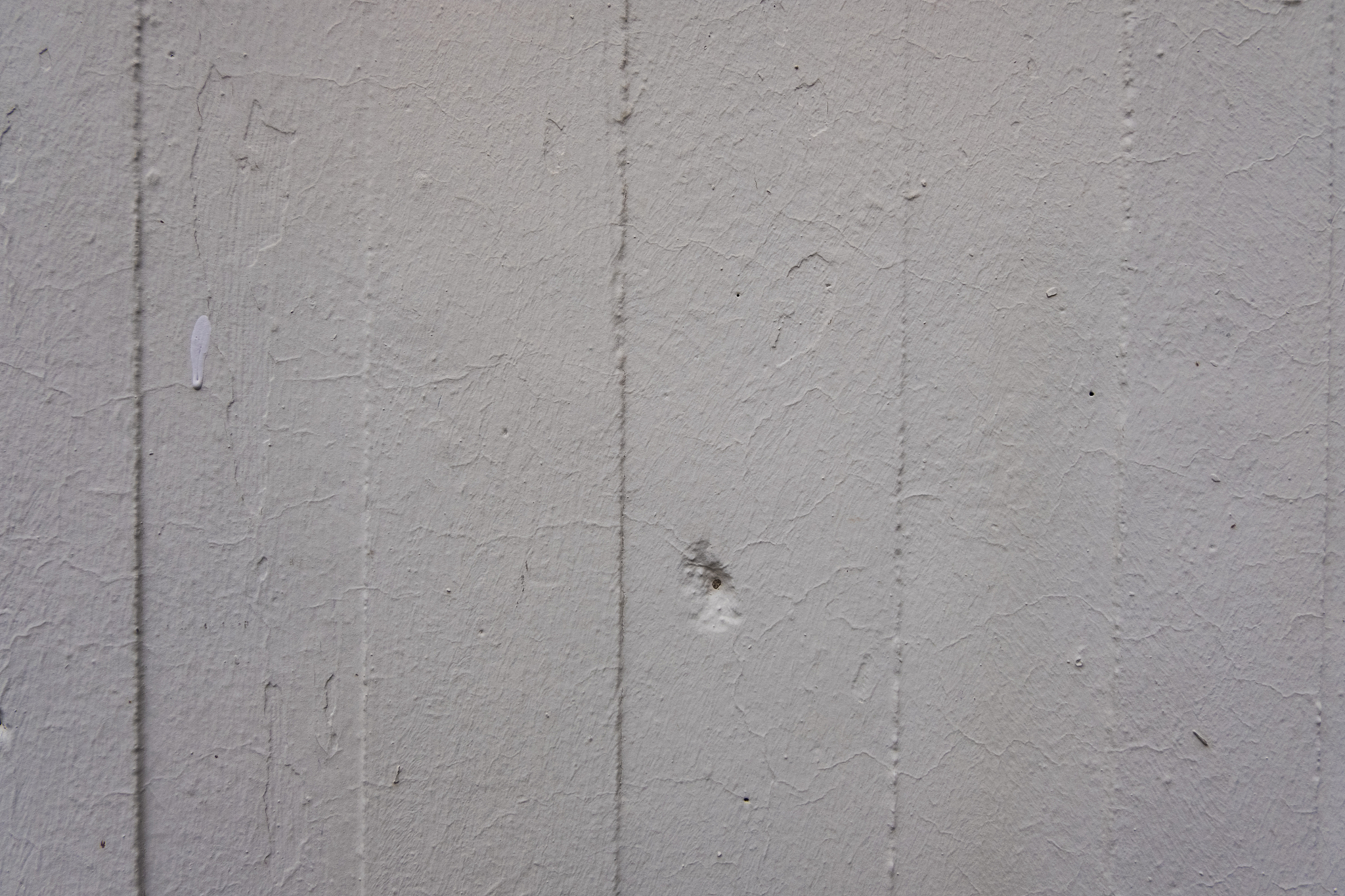 white vertical bars wall with scratches and a hole.