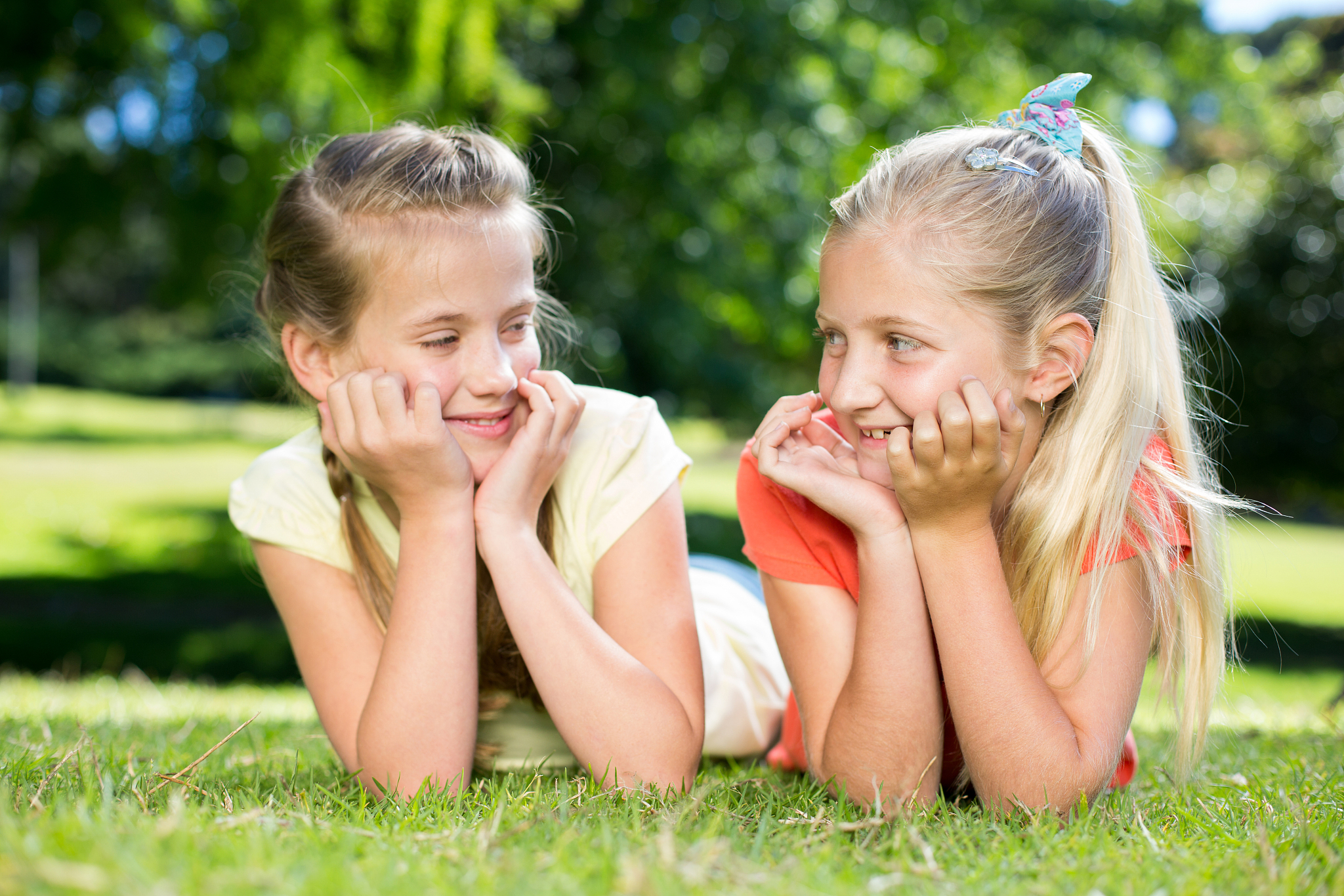 happy sisters smiling to each other