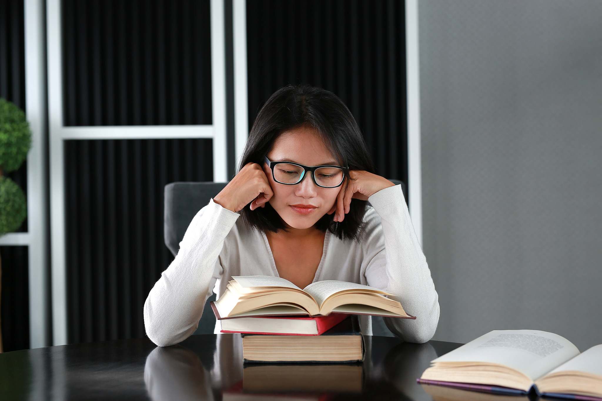 asian woman reading a book in the library.