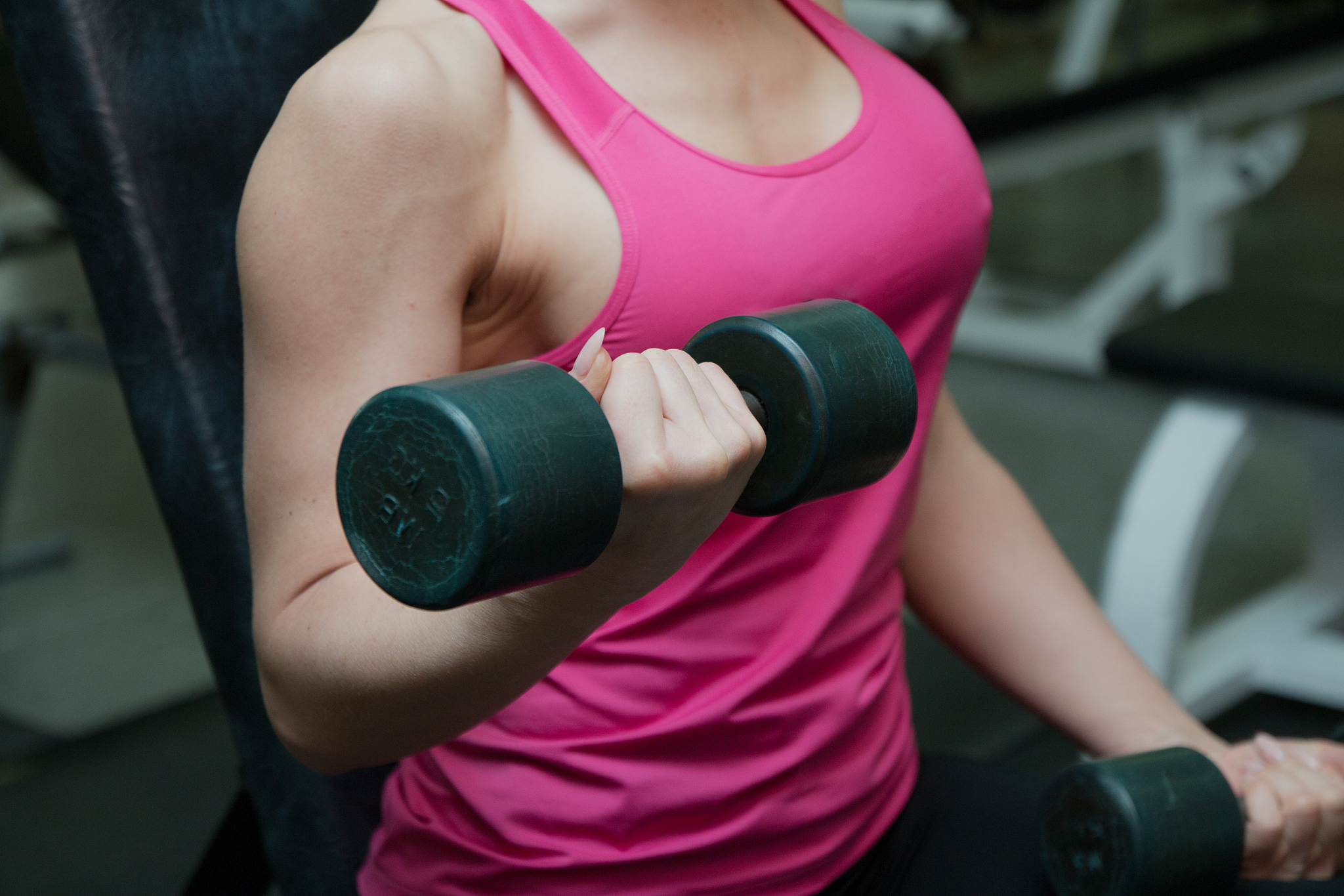 beautiful girl exercising in fitness club with dumbbells