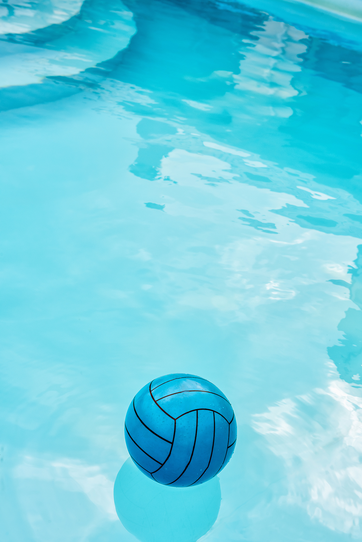 vertical image of blue ball in blue pool