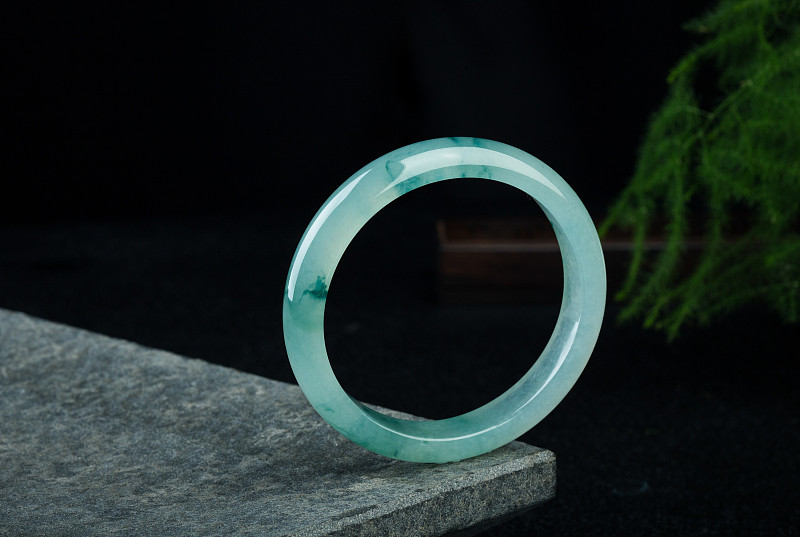 糯种翡翠是目前市场上最常见的翡翠它的糯就是它里面变现的絮棉由于絮棉的分散程度和厚度影响翡翠的材质和细腻度因而影响它的市场价值。糯种翡翠的透明度低比冰种翡翠的质地要粗在我们看来就是像米汤比较浑浊。但是给人一种柔和的感觉外观还是挺好看的属于中上等翡翠价格也比较适中在市场上最受欢迎的翡翠。