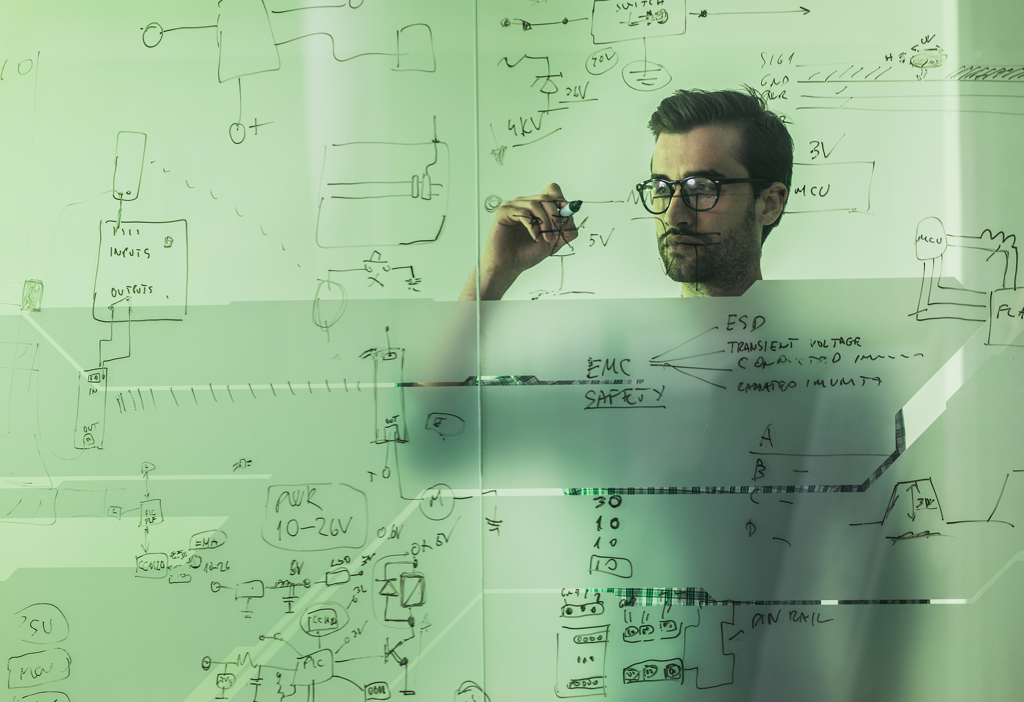young engineer drawing business ideas on a glass in the office.
