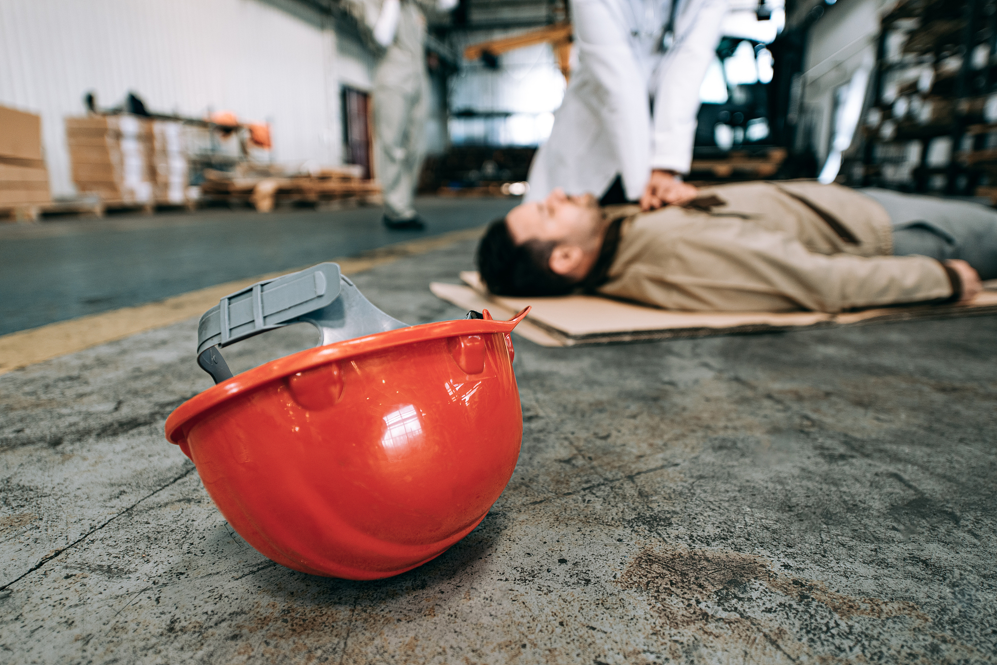 unconscious worker lying on a warehouse floor.